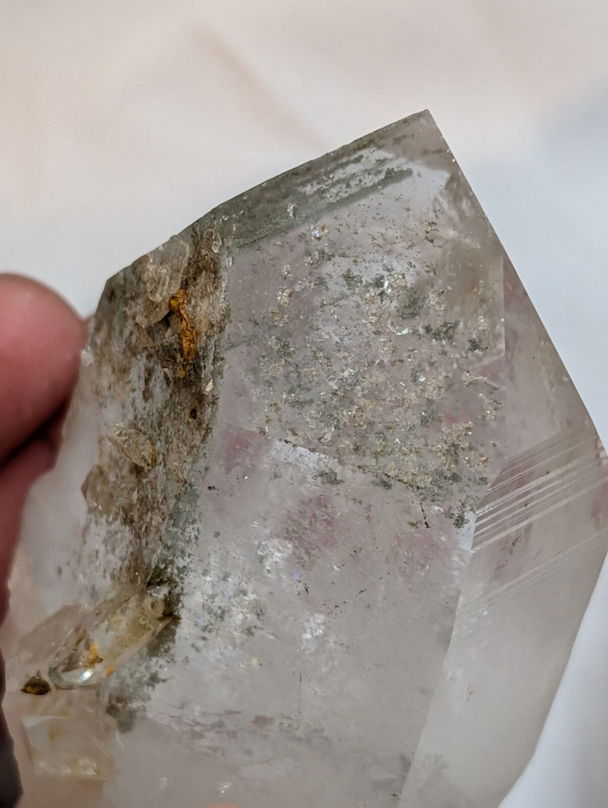 A translucent, geometrically faceted quartz crystal with natural inclusions and subtle internal striations.