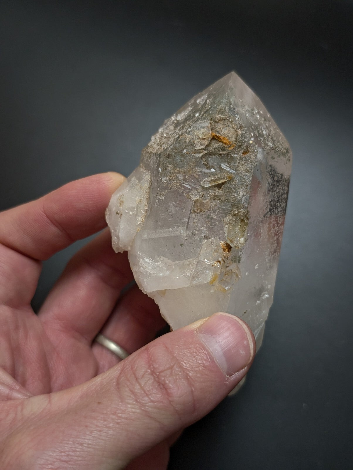 A translucent, clear quartz crystal with natural inclusions and a pointed tip.
