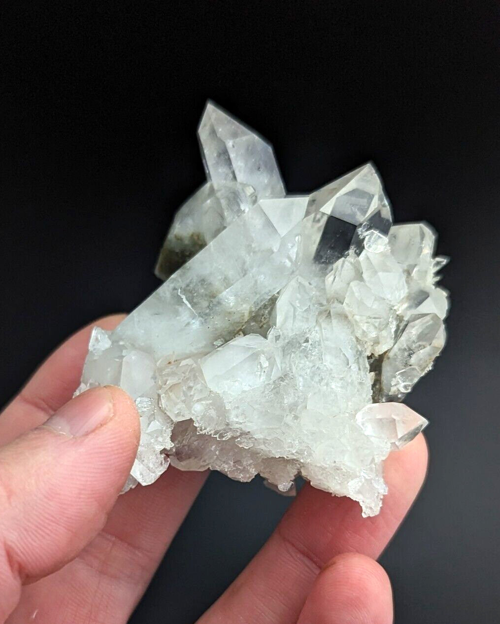 A translucent, clear quartz crystal cluster with sharp facets and a slightly cloudy base.