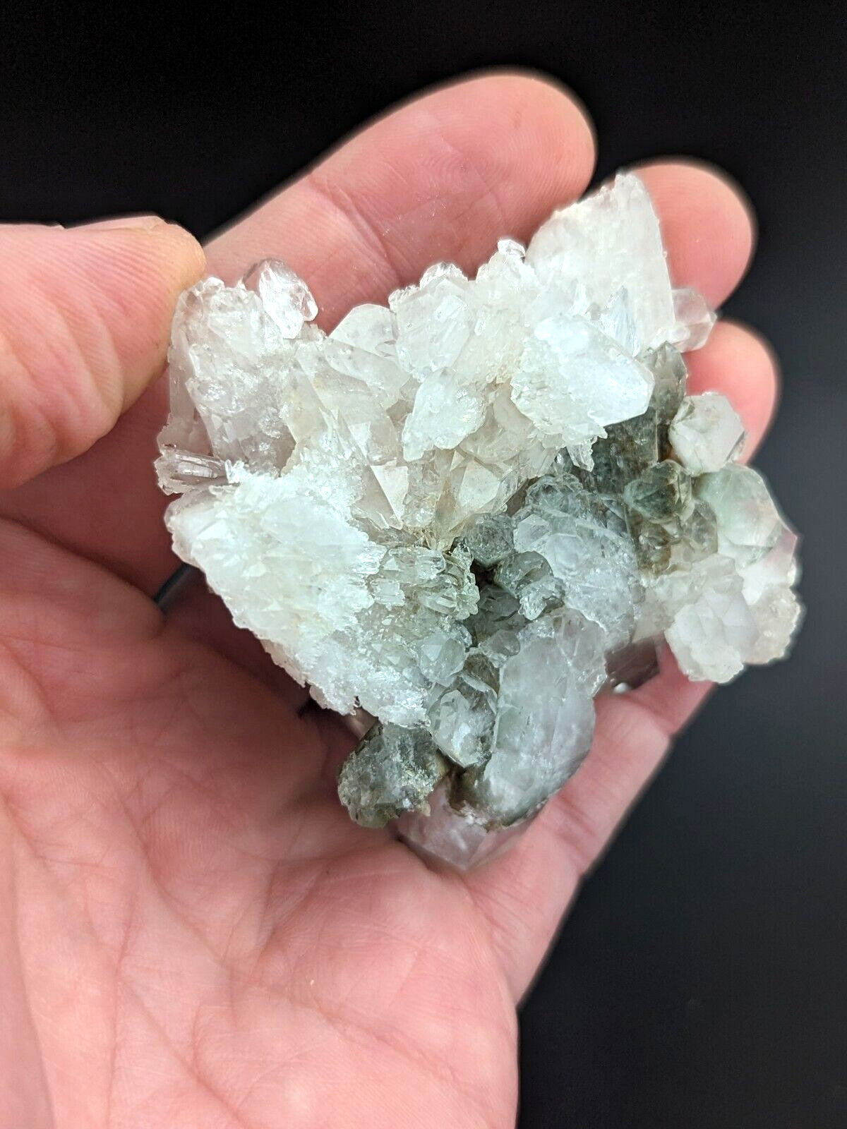 A translucent, crystalline mineral specimen with a mix of clear and pale green hues.