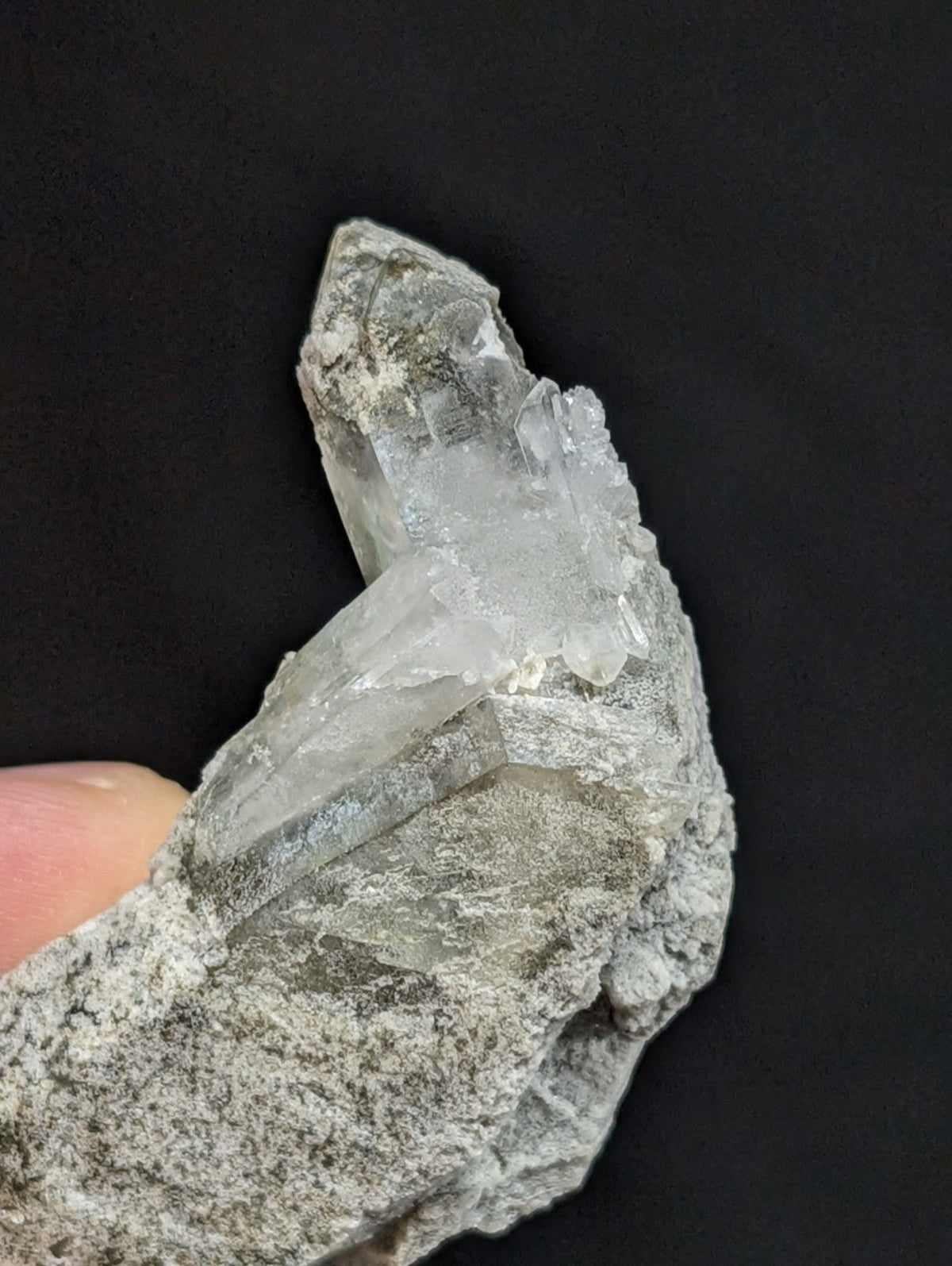 A translucent, crystalline quartz specimen with sharp facets and a pale gray matrix.
