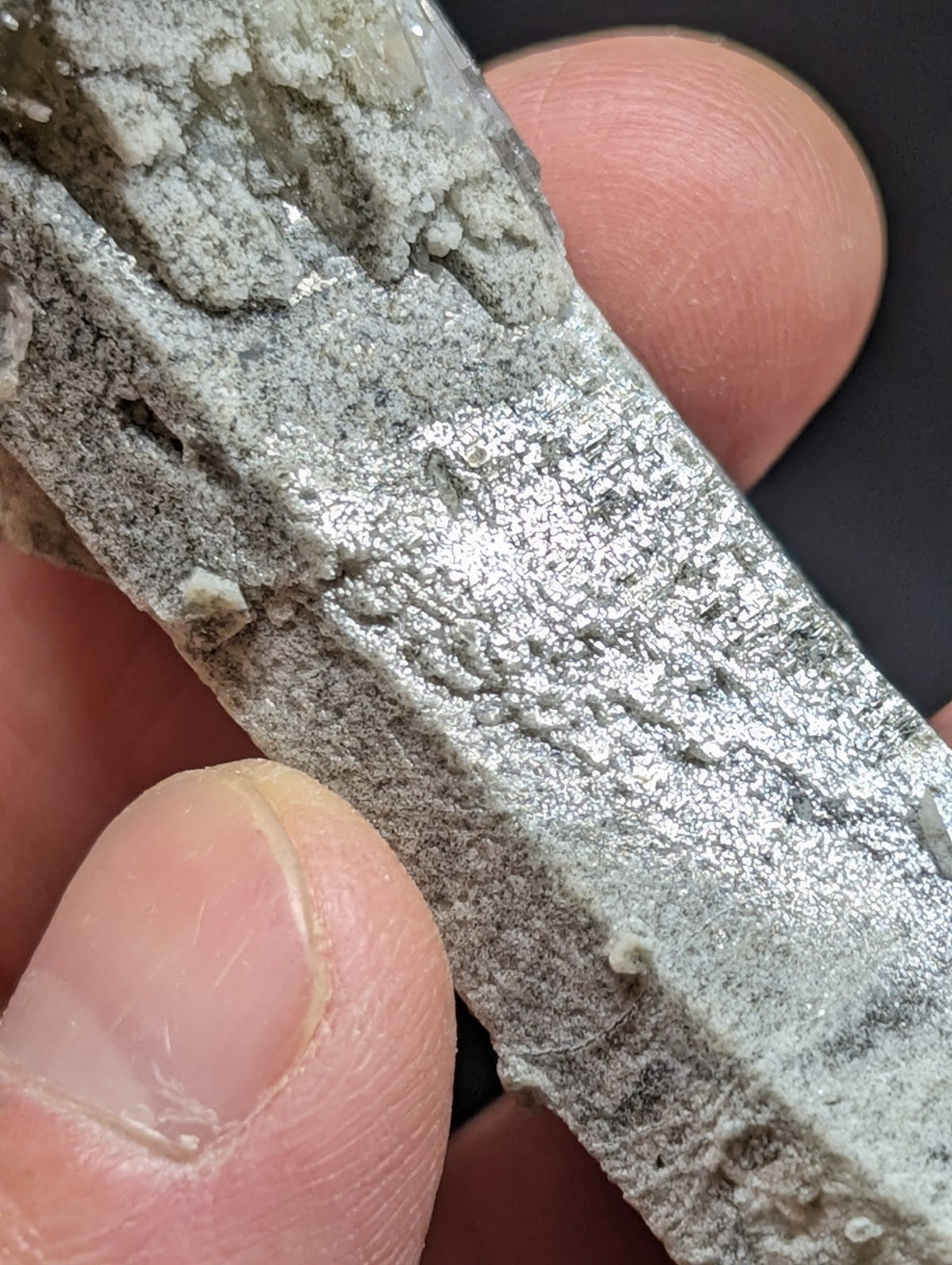A rough, grayish metallic mineral specimen with a textured surface and visible crystalline formations.