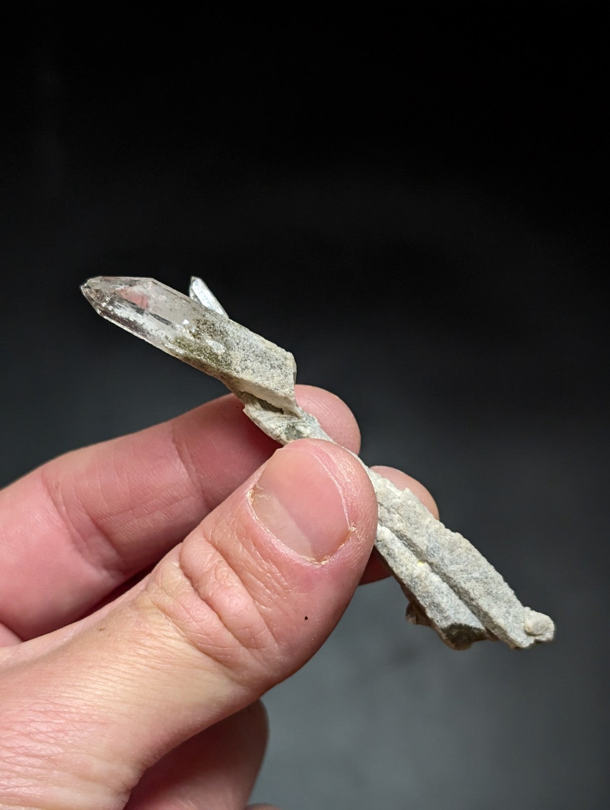 A translucent, clear quartz crystal with a pointed tip and visible internal inclusions.