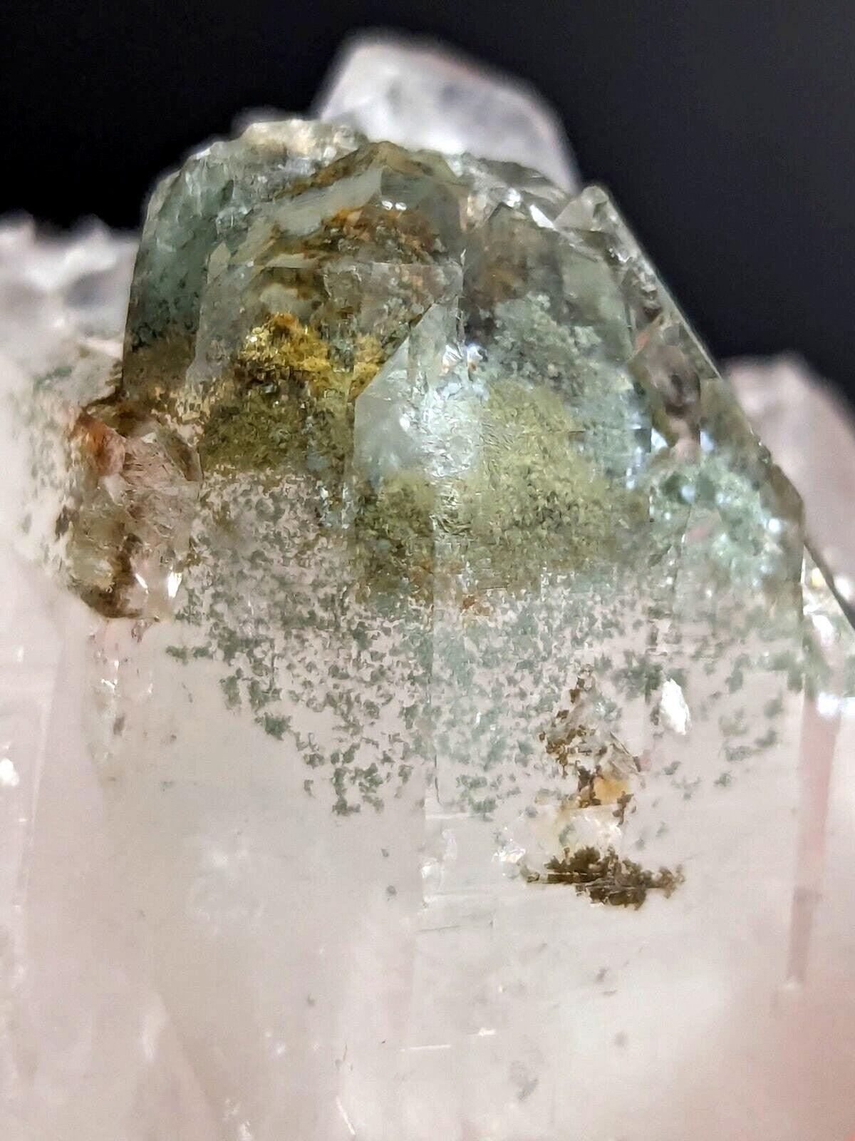 A translucent green and clear quartz crystal cluster with embedded golden mineral inclusions.