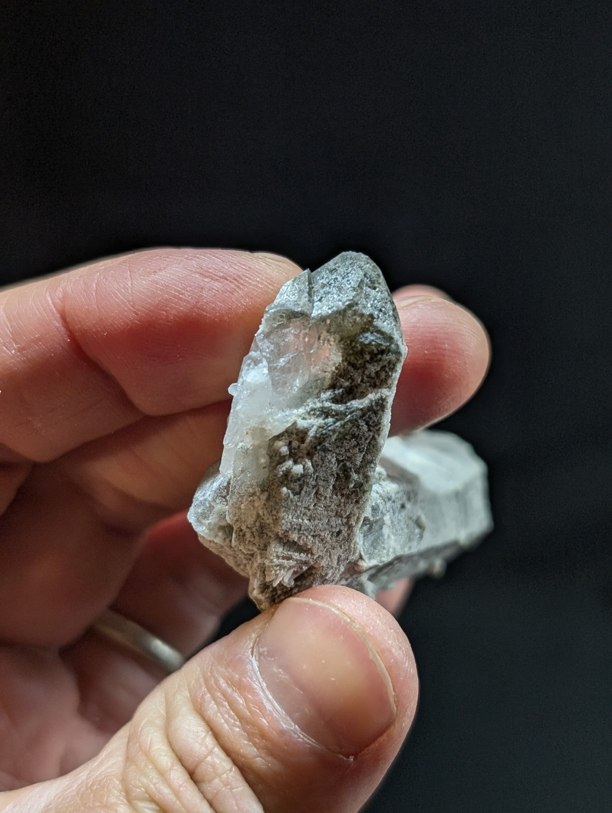 A translucent, grayish-white quartz crystal cluster with rough, jagged edges and a natural, earthy matrix.