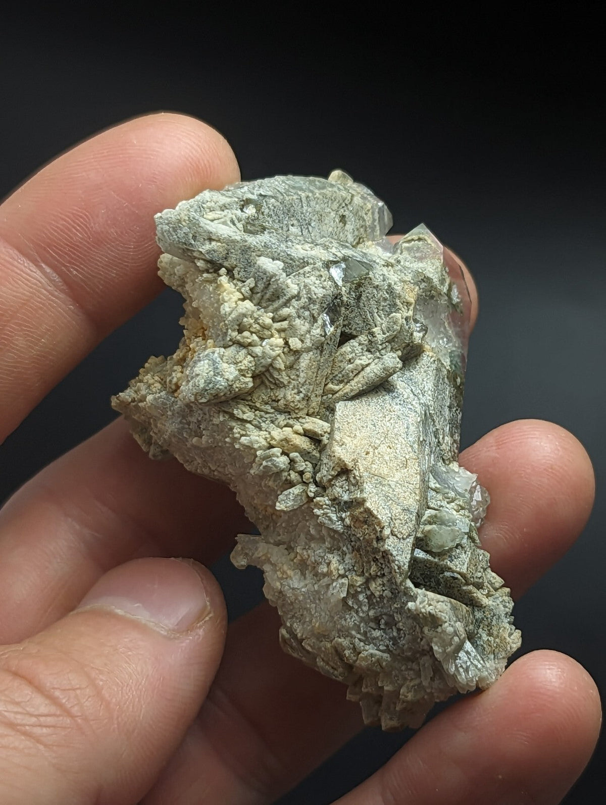 A rough, irregularly shaped mineral specimen with a mix of pale green and translucent crystalline formations.