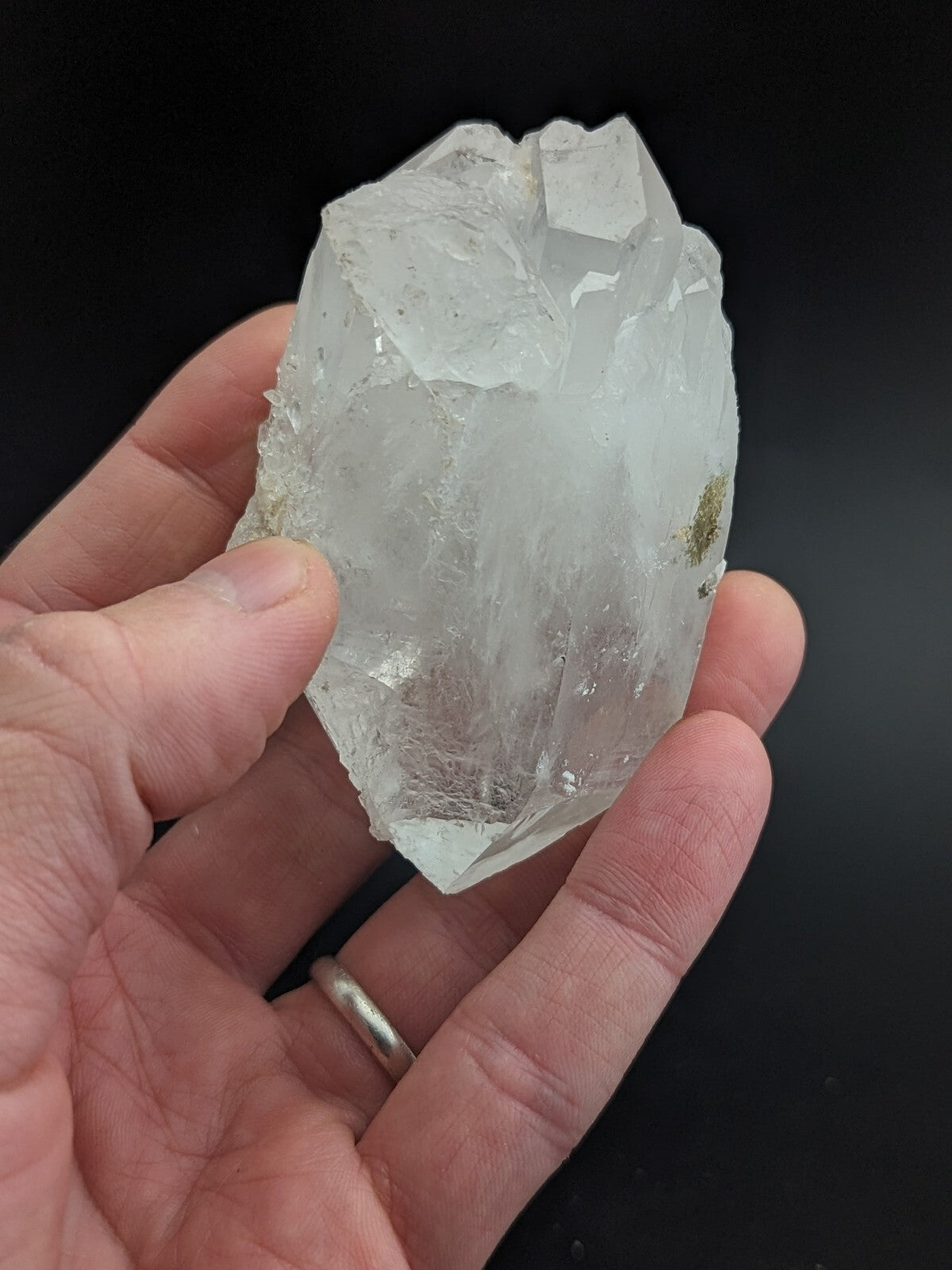 A translucent, clear quartz crystal with a rough, jagged surface and subtle internal inclusions.