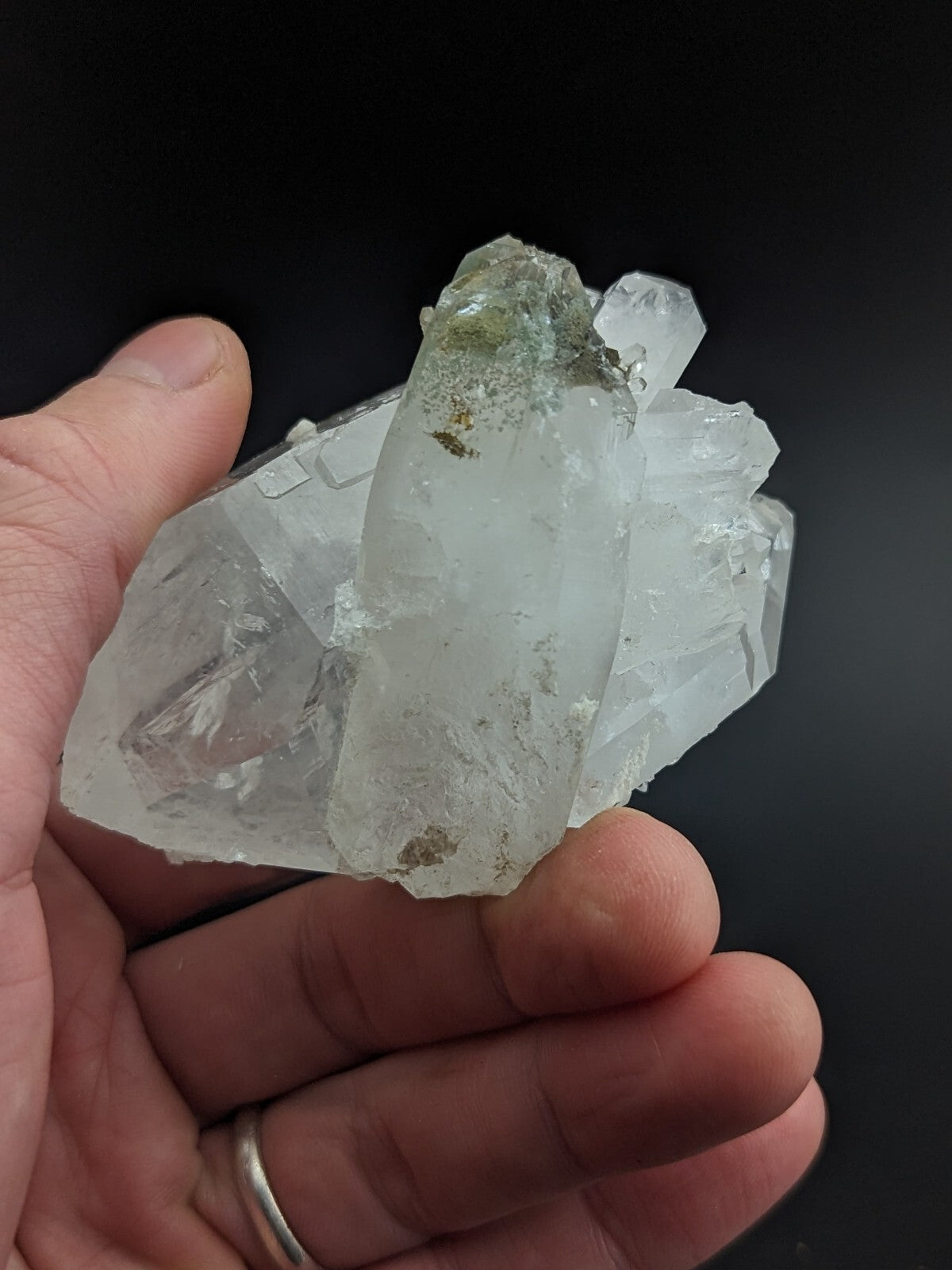 A translucent, clear quartz crystal cluster with subtle greenish tints and natural imperfections.