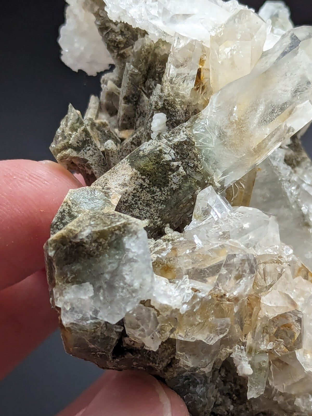 A translucent, crystalline mineral specimen with clear and milky quartz crystals growing from a greenish-gray matrix.