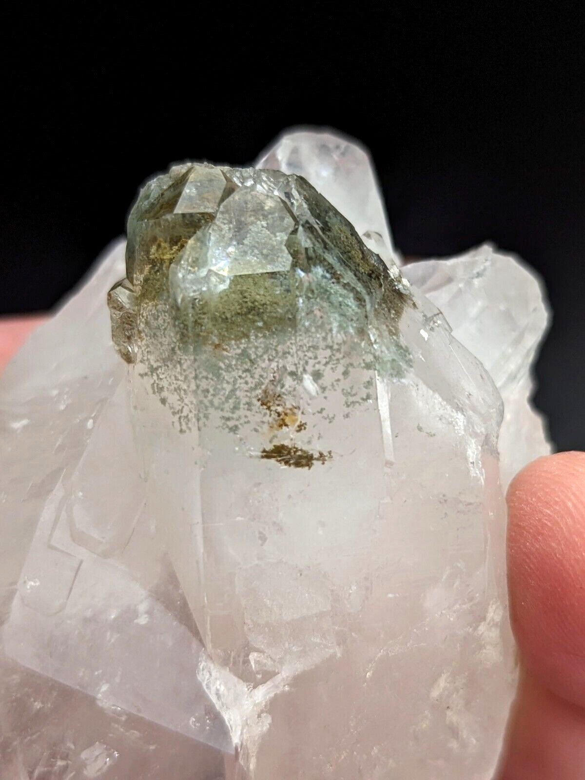 A translucent green and clear quartz crystal cluster with a faceted, natural formation.