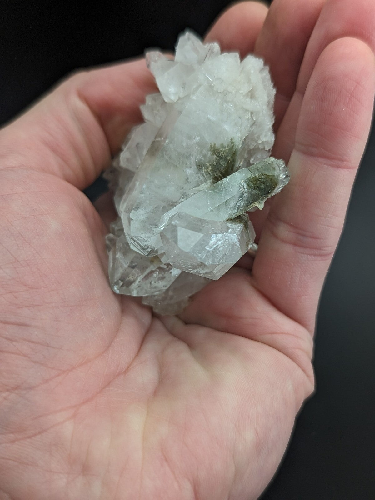 A translucent, crystalline mineral specimen with sharp facets and a pale greenish tint.
