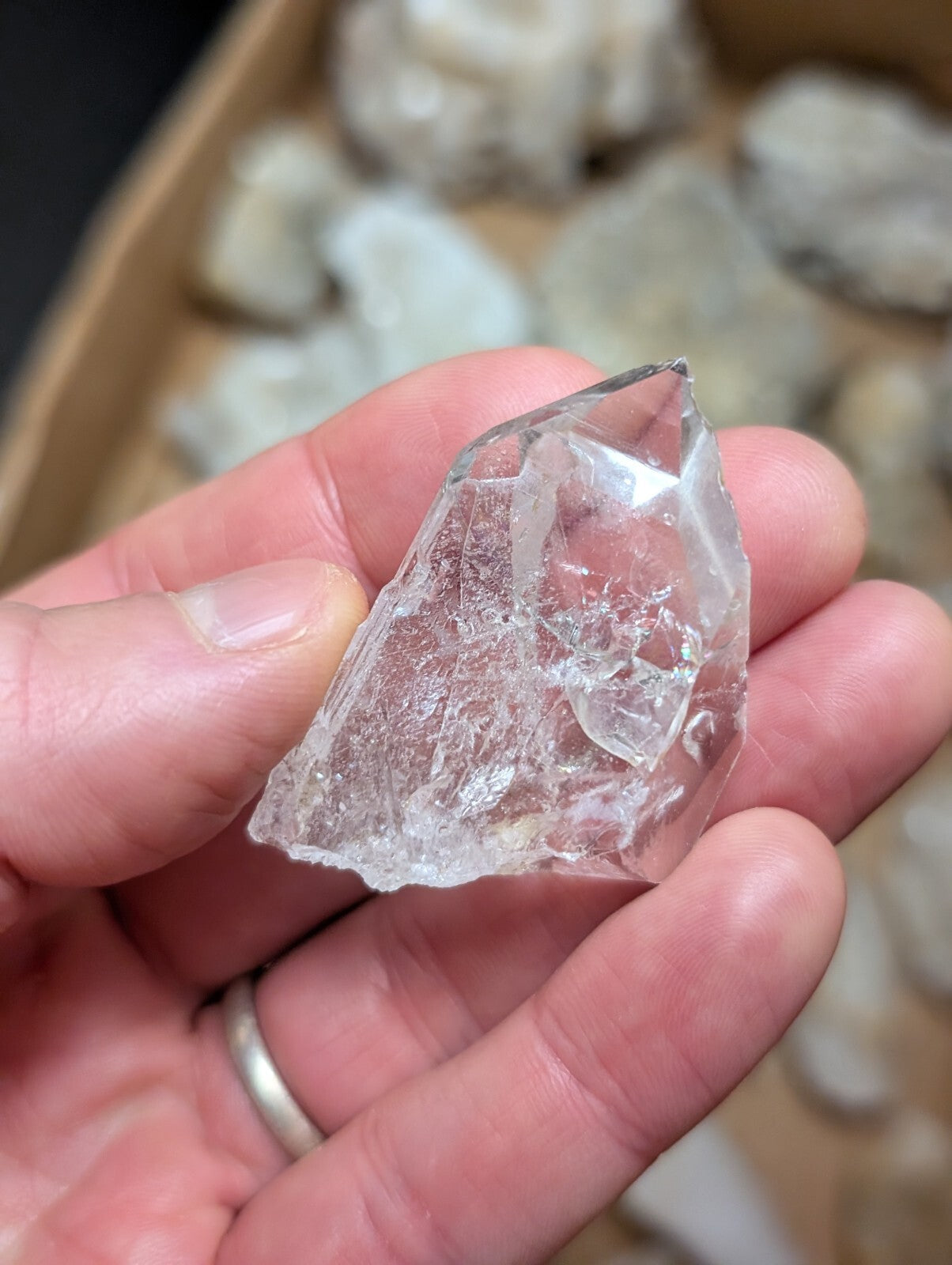 A clear, faceted quartz crystal with natural internal inclusions and a pointed tip.