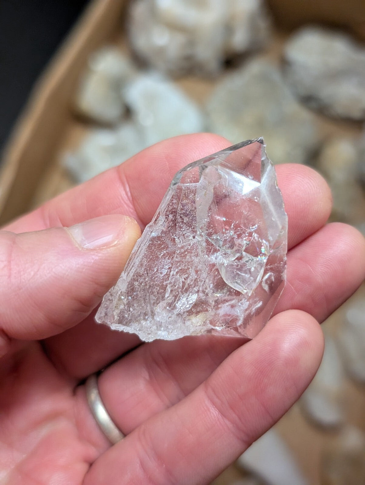 A clear, faceted quartz crystal with natural internal inclusions and a pointed tip.