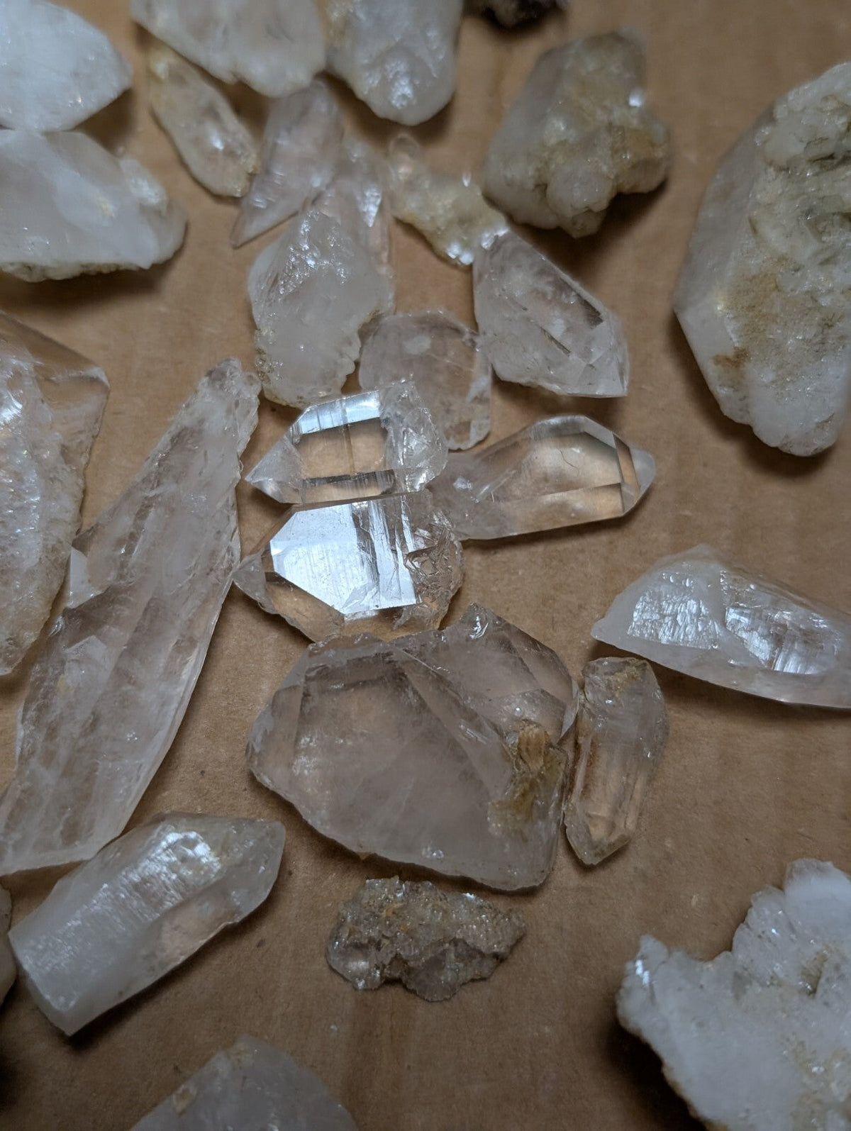 Clear quartz crystals of varying sizes and shapes, some with visible internal inclusions or facets.