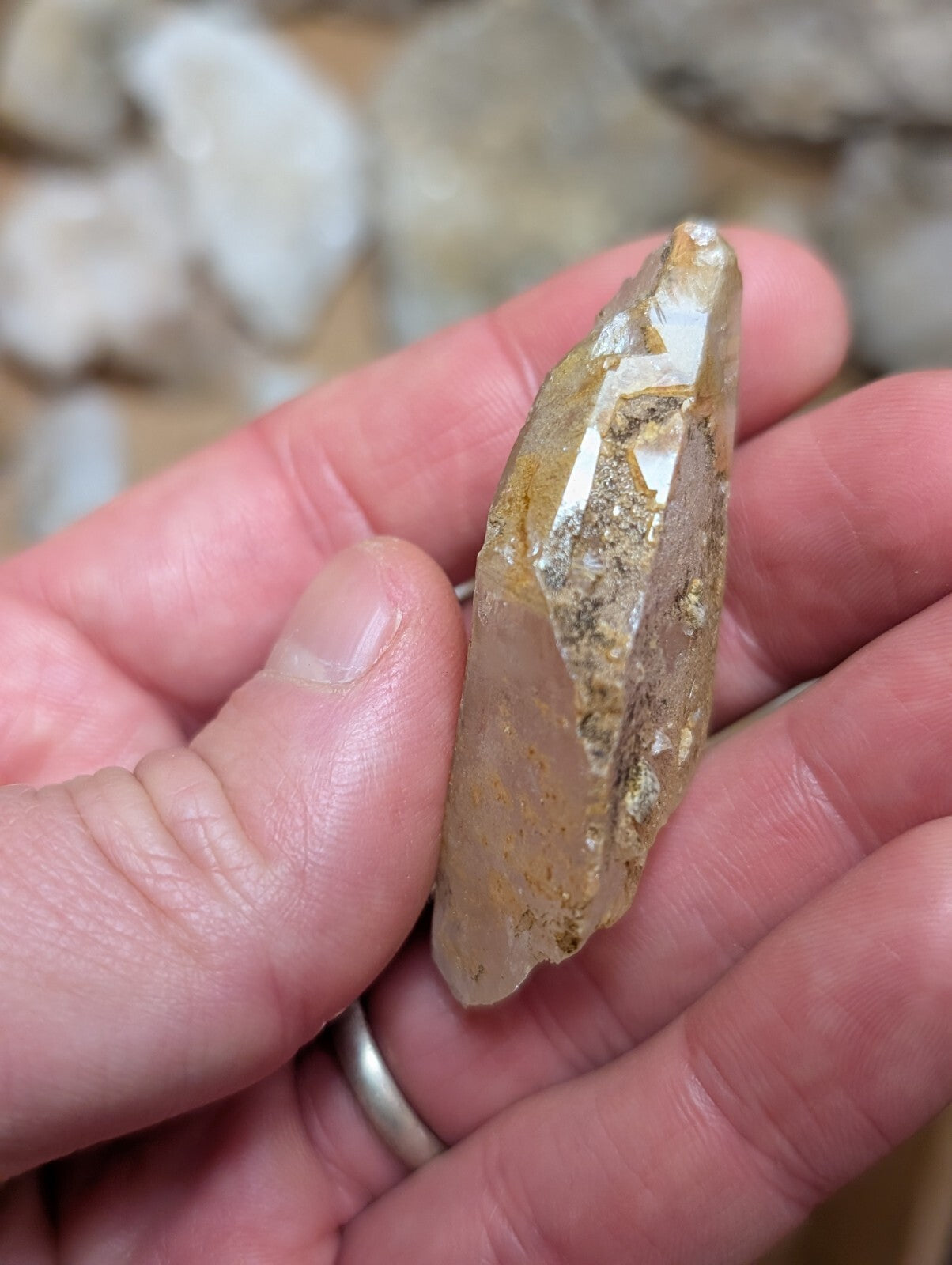 A translucent, golden-hued quartz crystal with natural inclusions and a pointed tip.