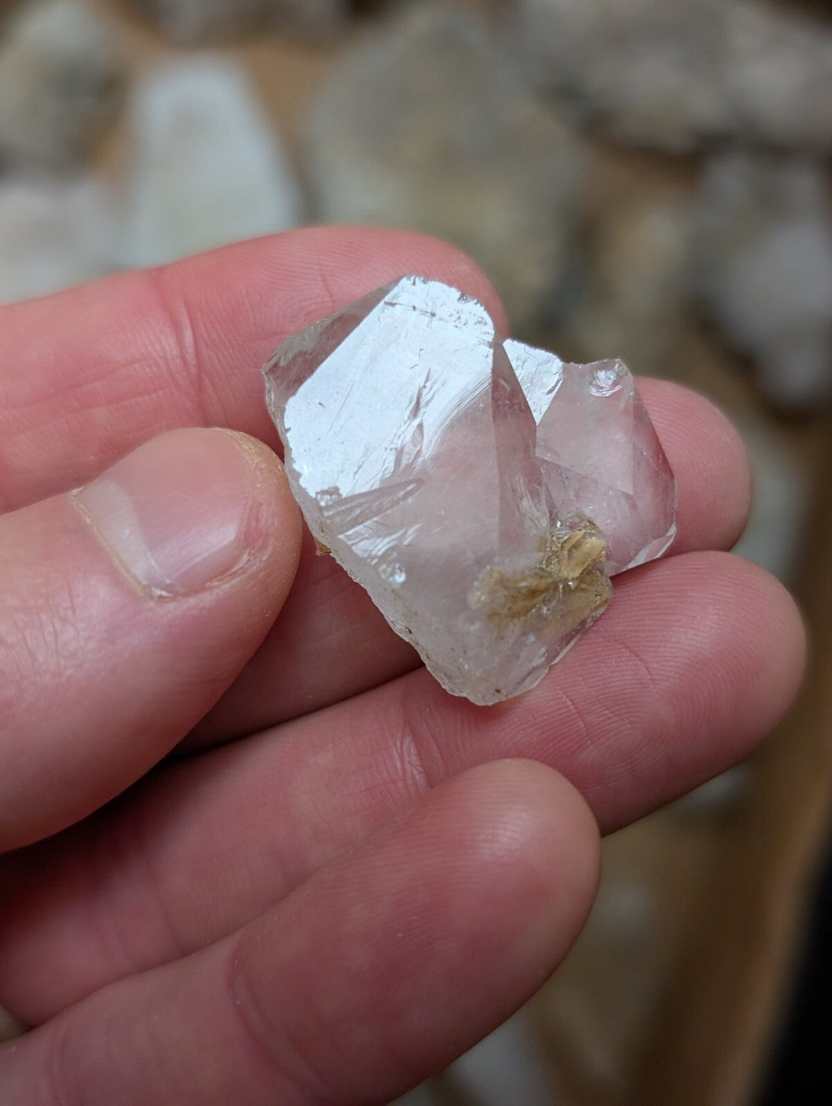 A translucent, clear quartz crystal cluster with a rough, faceted surface and subtle internal inclusions.
