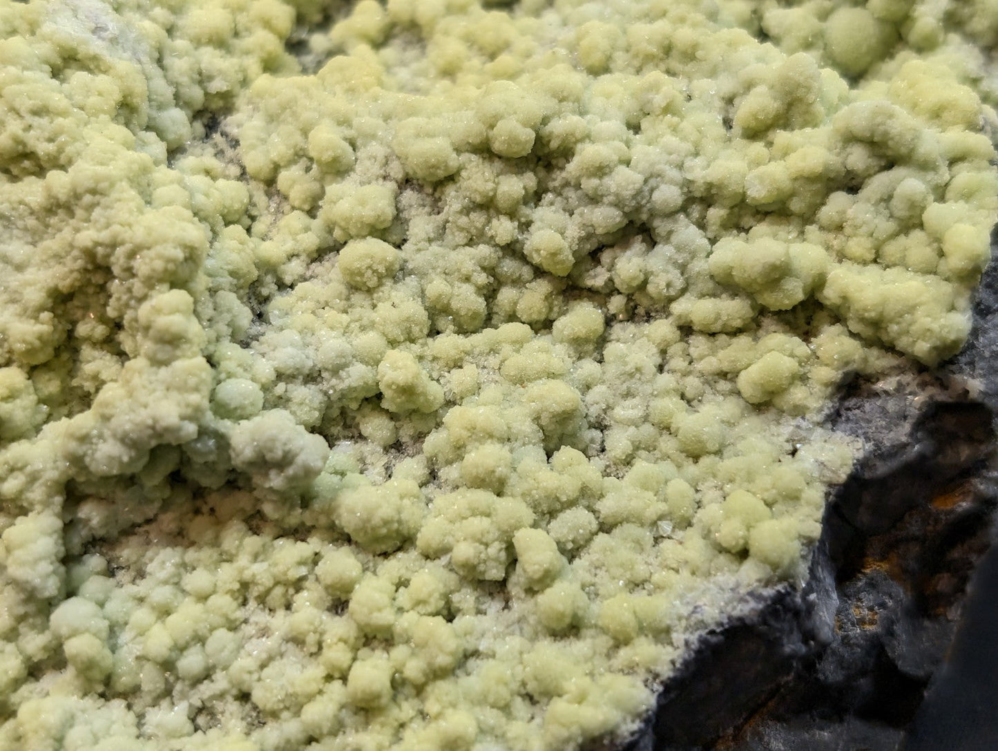 Pale yellow, crystalline mineral formation with a rough, textured surface.