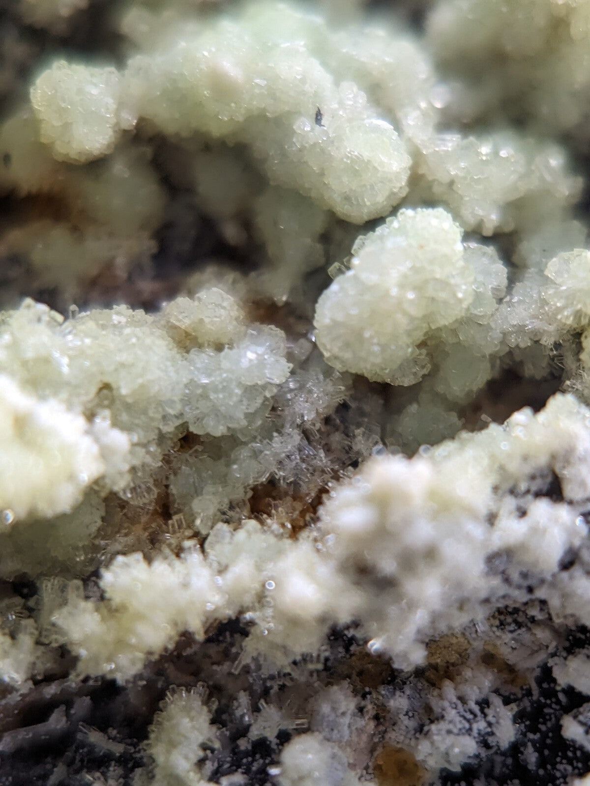 Iridescent white crystalline formations with a sugary, textured surface.