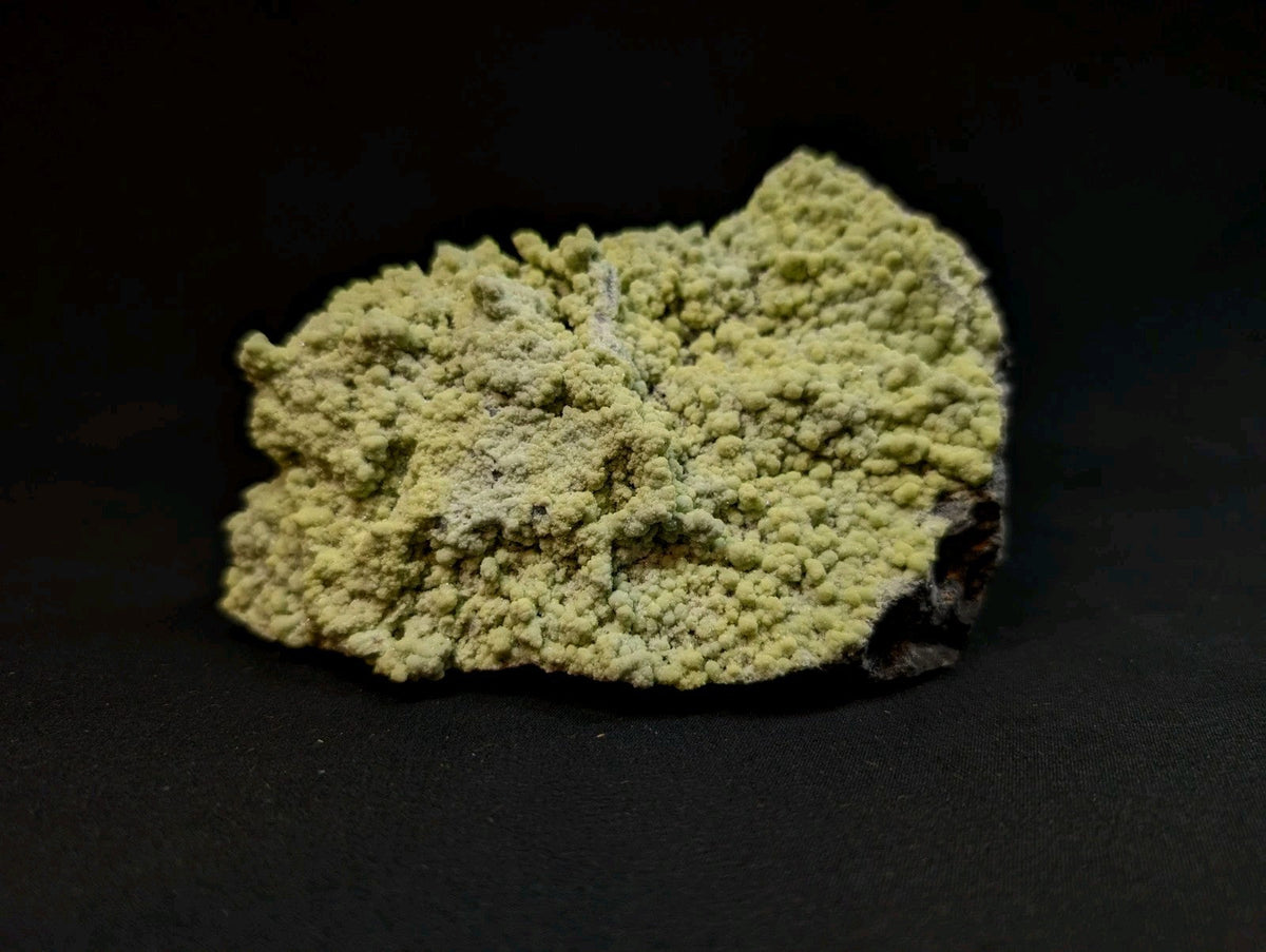 A textured, pale green mineral specimen with a rough, crystalline surface.