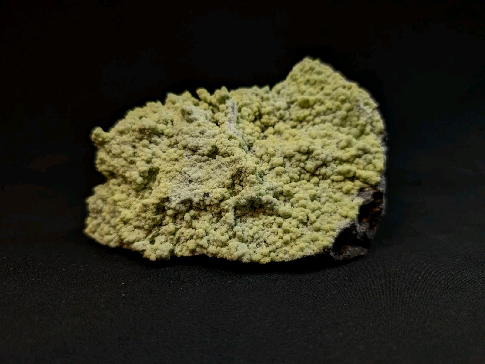 A textured, pale green mineral specimen with a rough, crystalline surface.