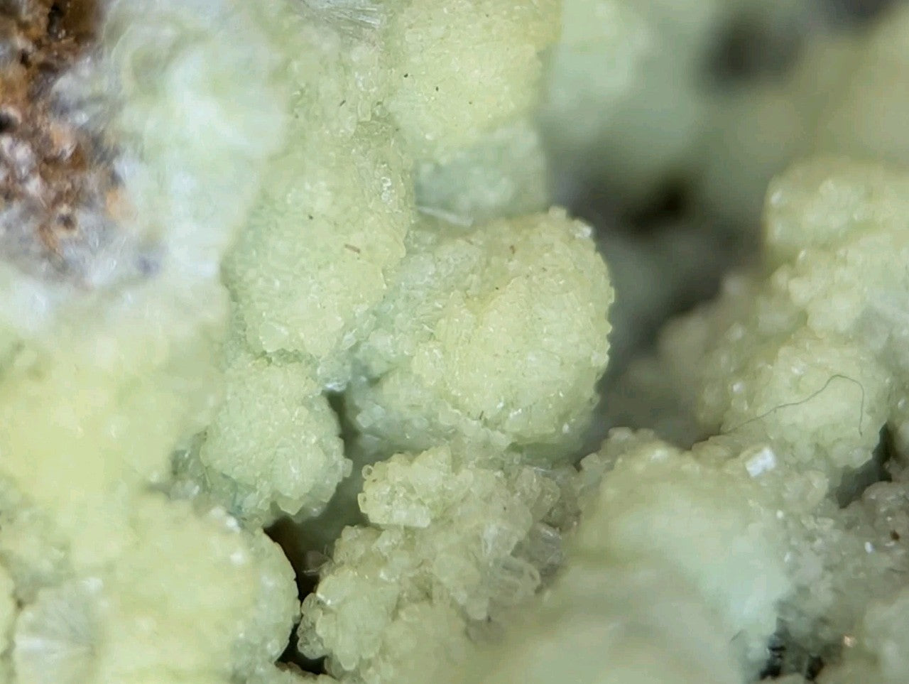 Pale green, crystalline mineral formations with a granular texture.