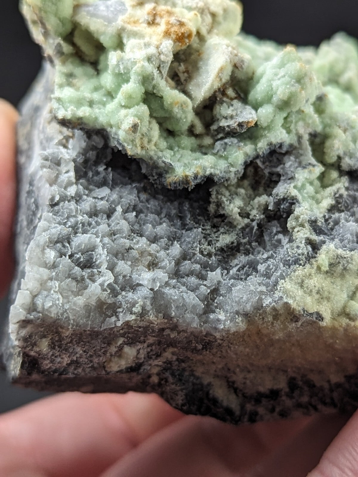 A textured mineral specimen featuring a gray crystalline base with vibrant green, moss-like formations on top.
