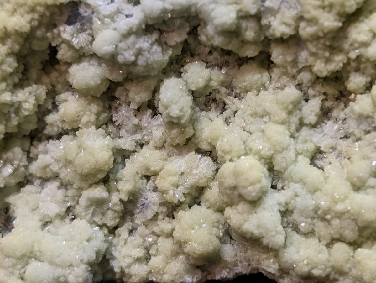 A cluster of pale, crystalline mineral formations with a textured, cauliflower-like surface.