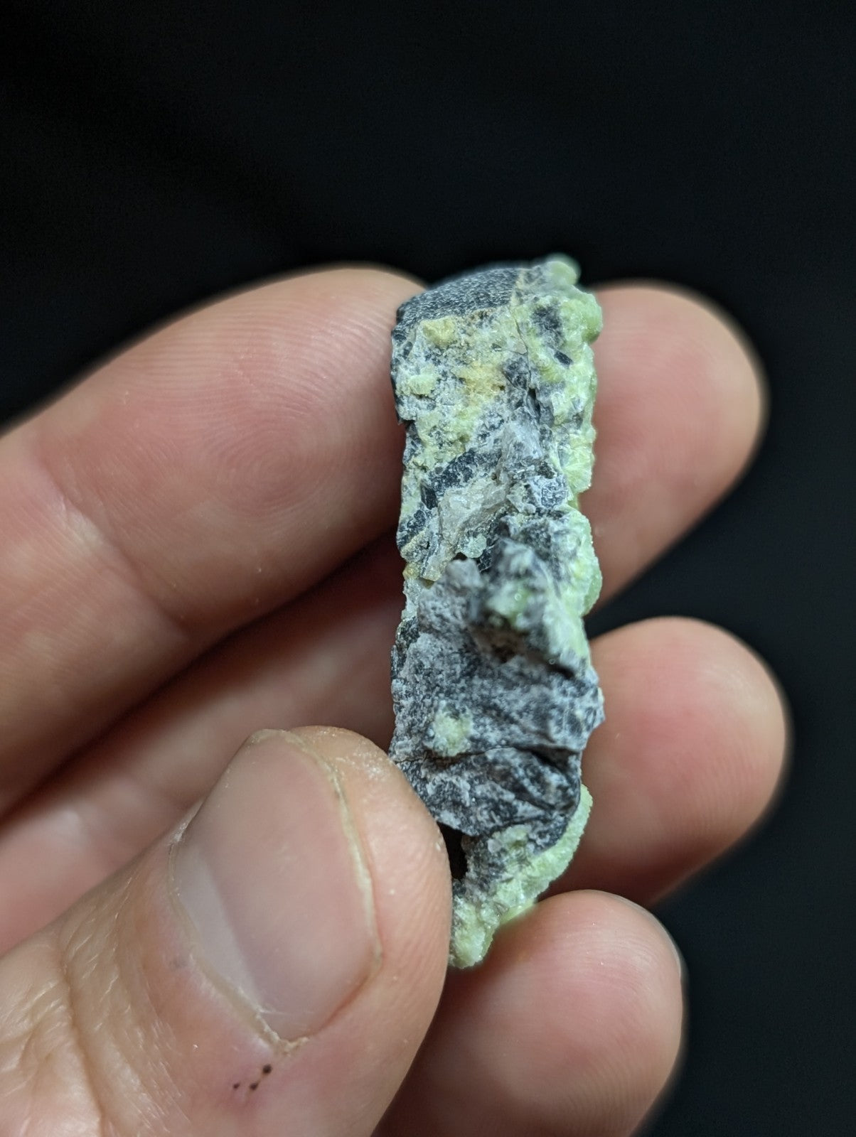 A weathered, rectangular piece of corroded metal with a mottled green and gray patina.