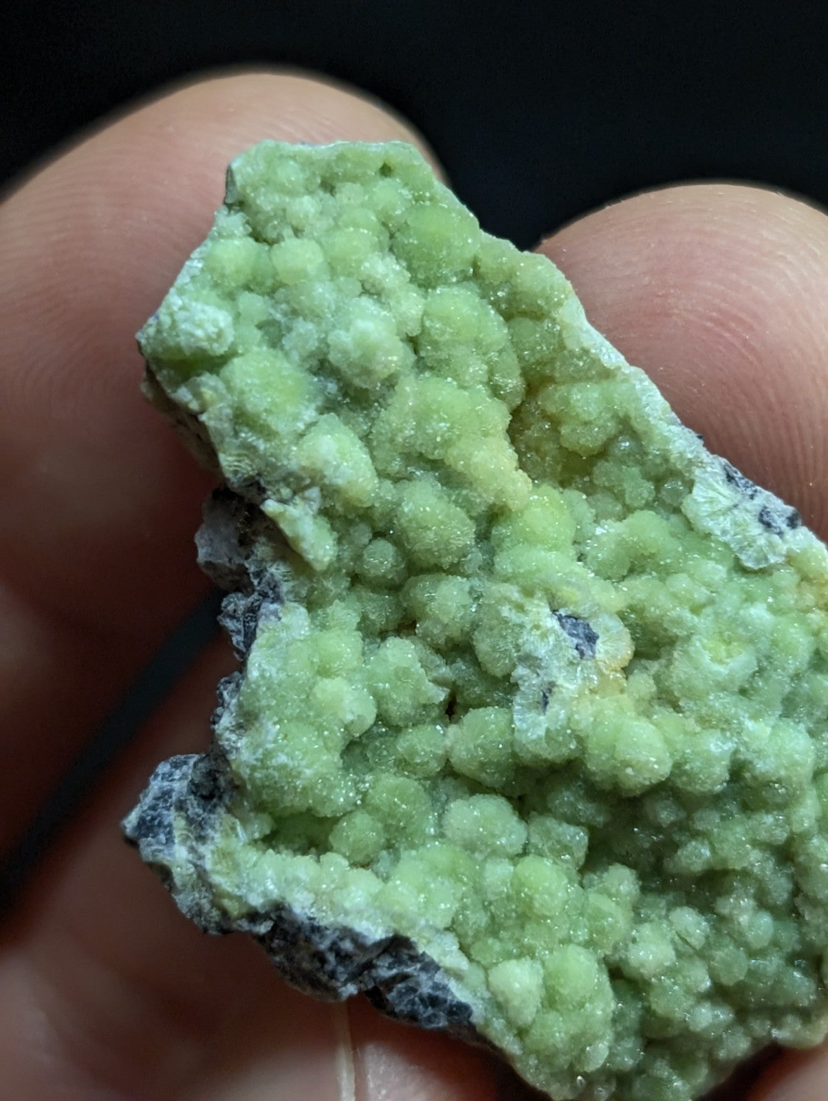 A light green, crystalline mineral specimen with rounded, bulbous formations and a rough, textured surface.