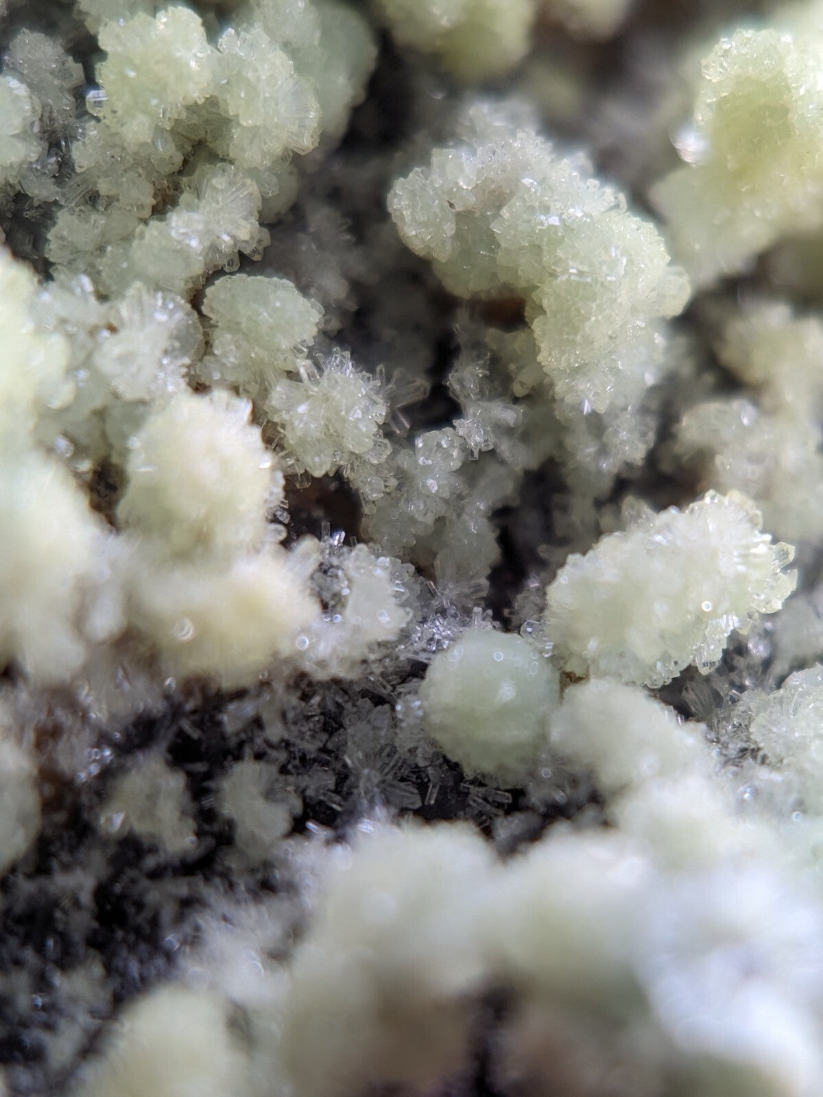 Crystalline mineral formations with translucent, pale greenish-white crystals clustered together.