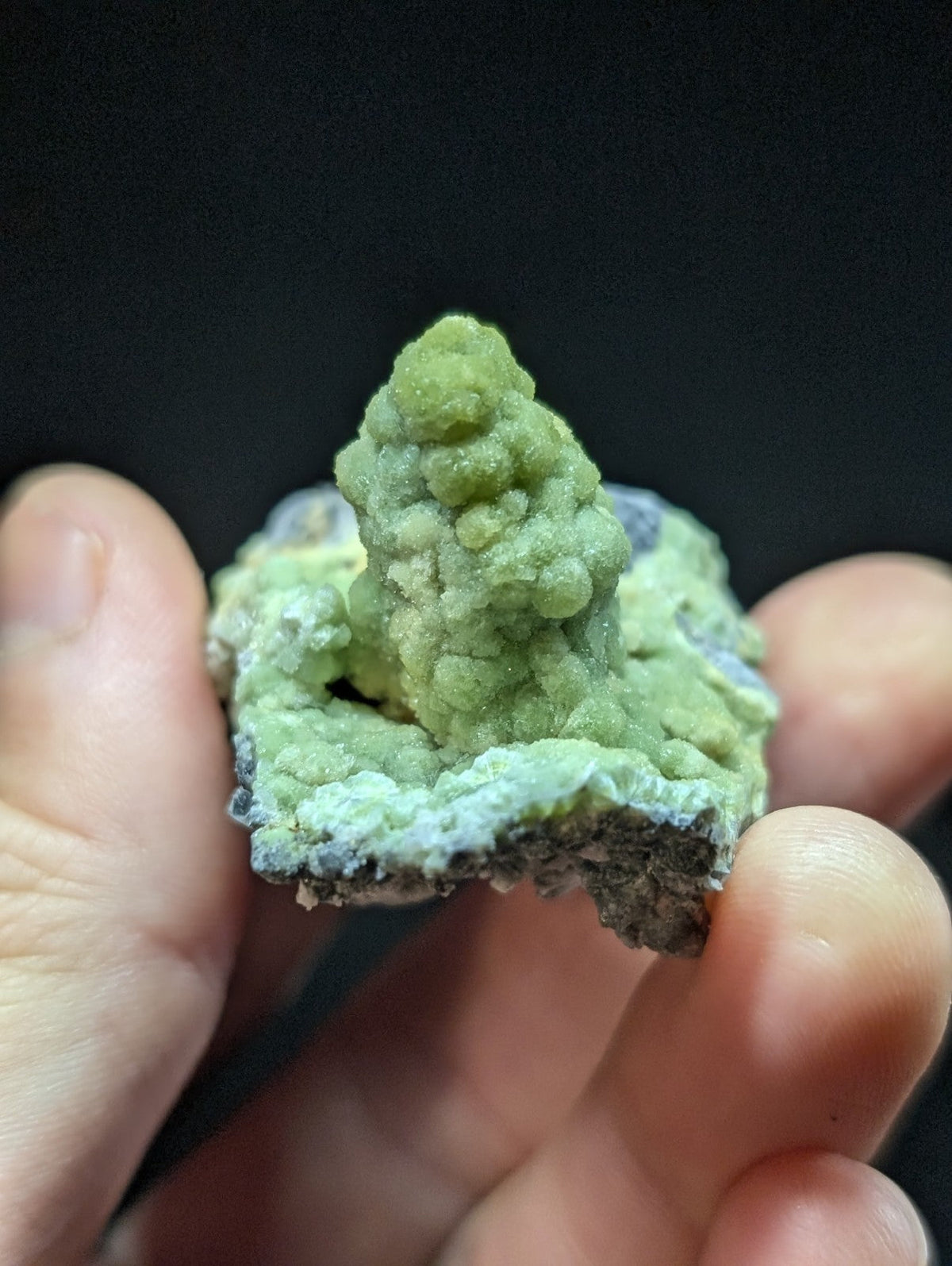 A vibrant green, textured mineral specimen with a mossy, cauliflower-like formation atop a rougher base.