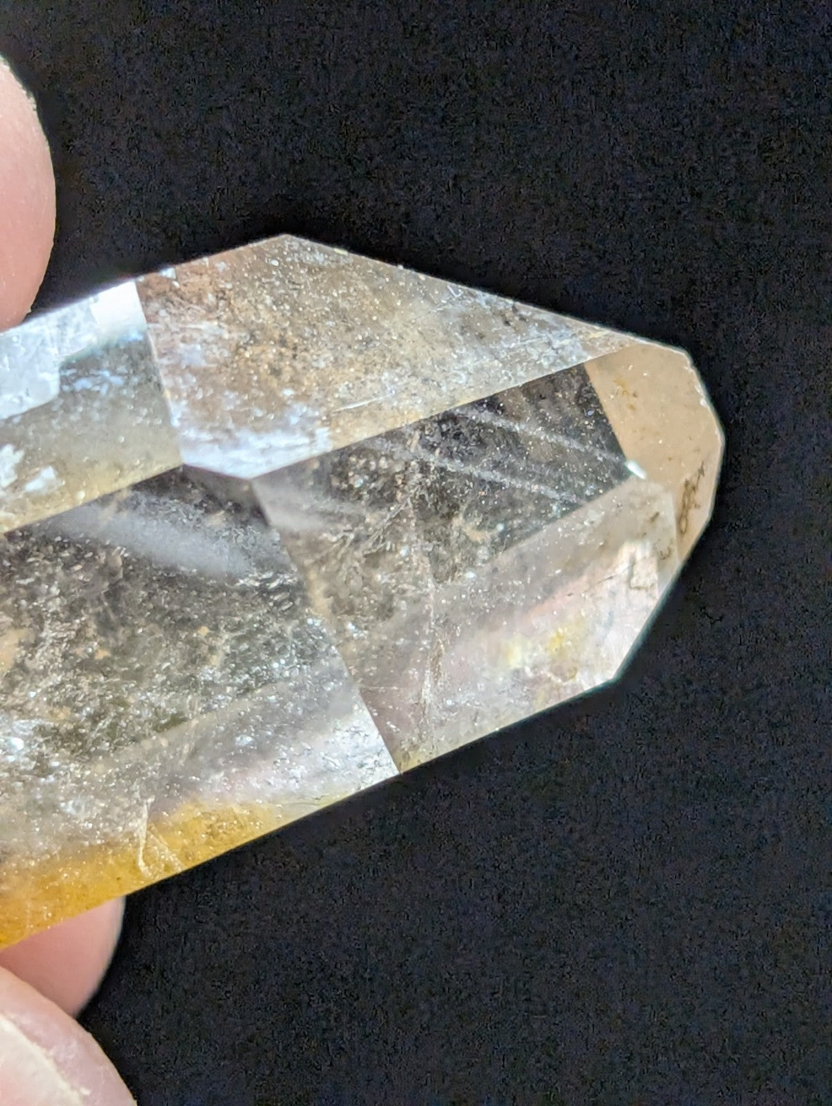 A translucent, faceted quartz crystal with a subtle golden hue and natural inclusions.