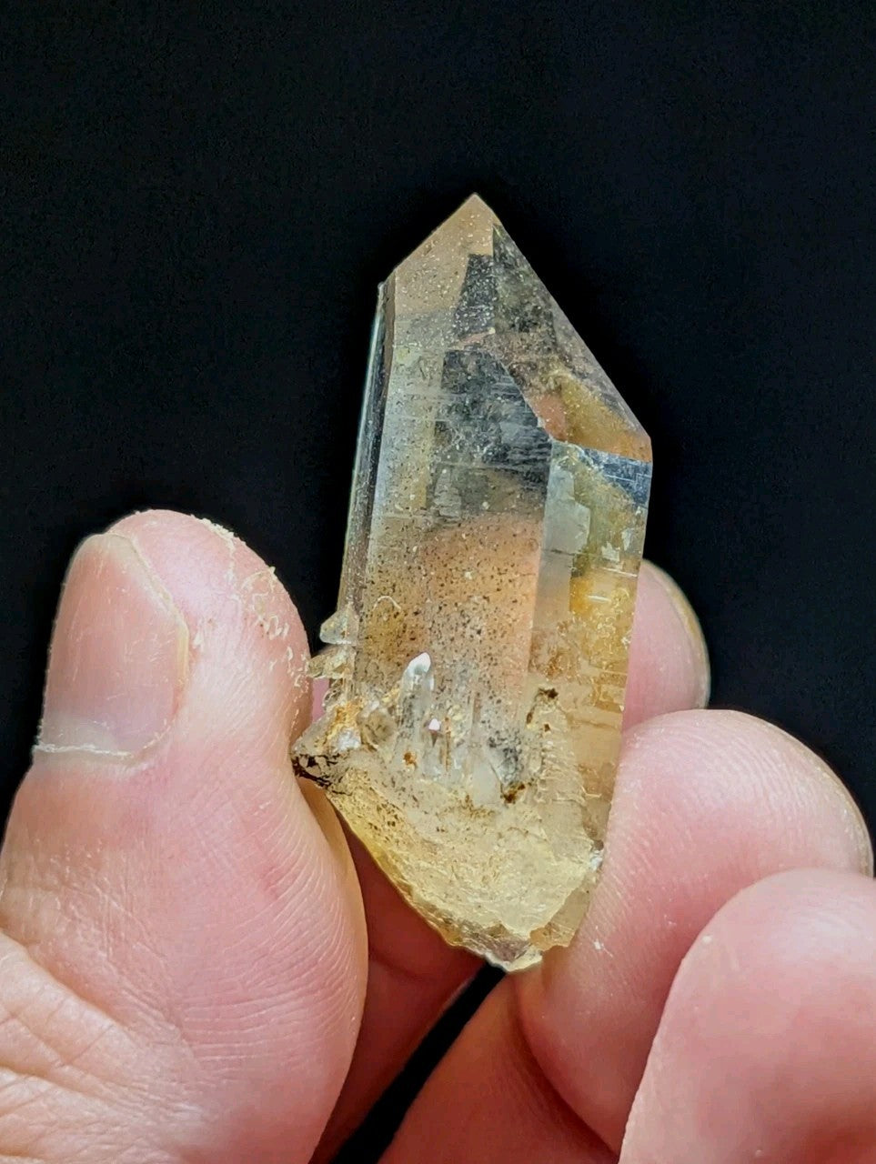 A translucent, amber-hued quartz crystal with a pointed tip and natural inclusions.