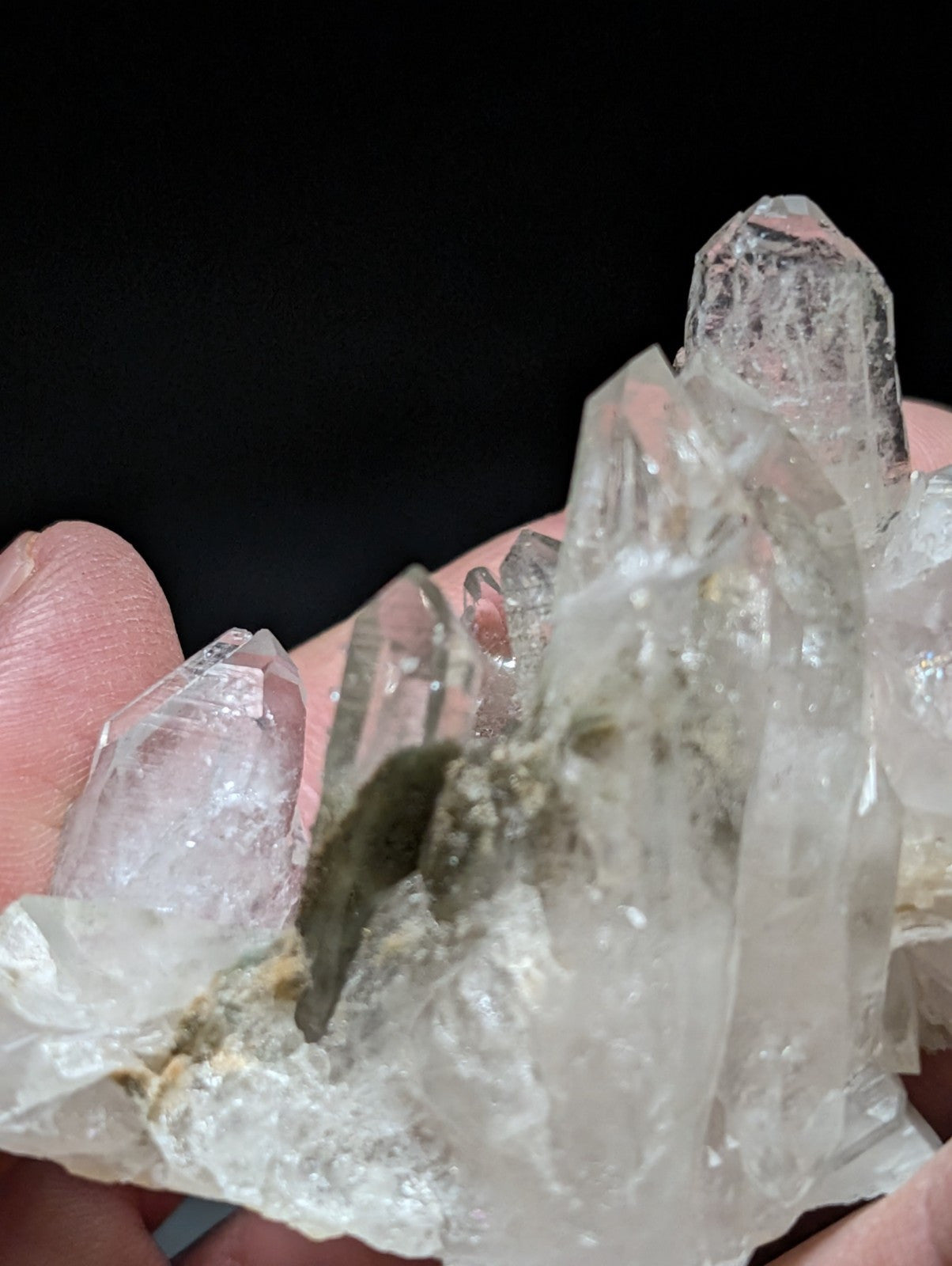 A translucent, clear quartz crystal cluster with sharp facets and a natural base matrix.