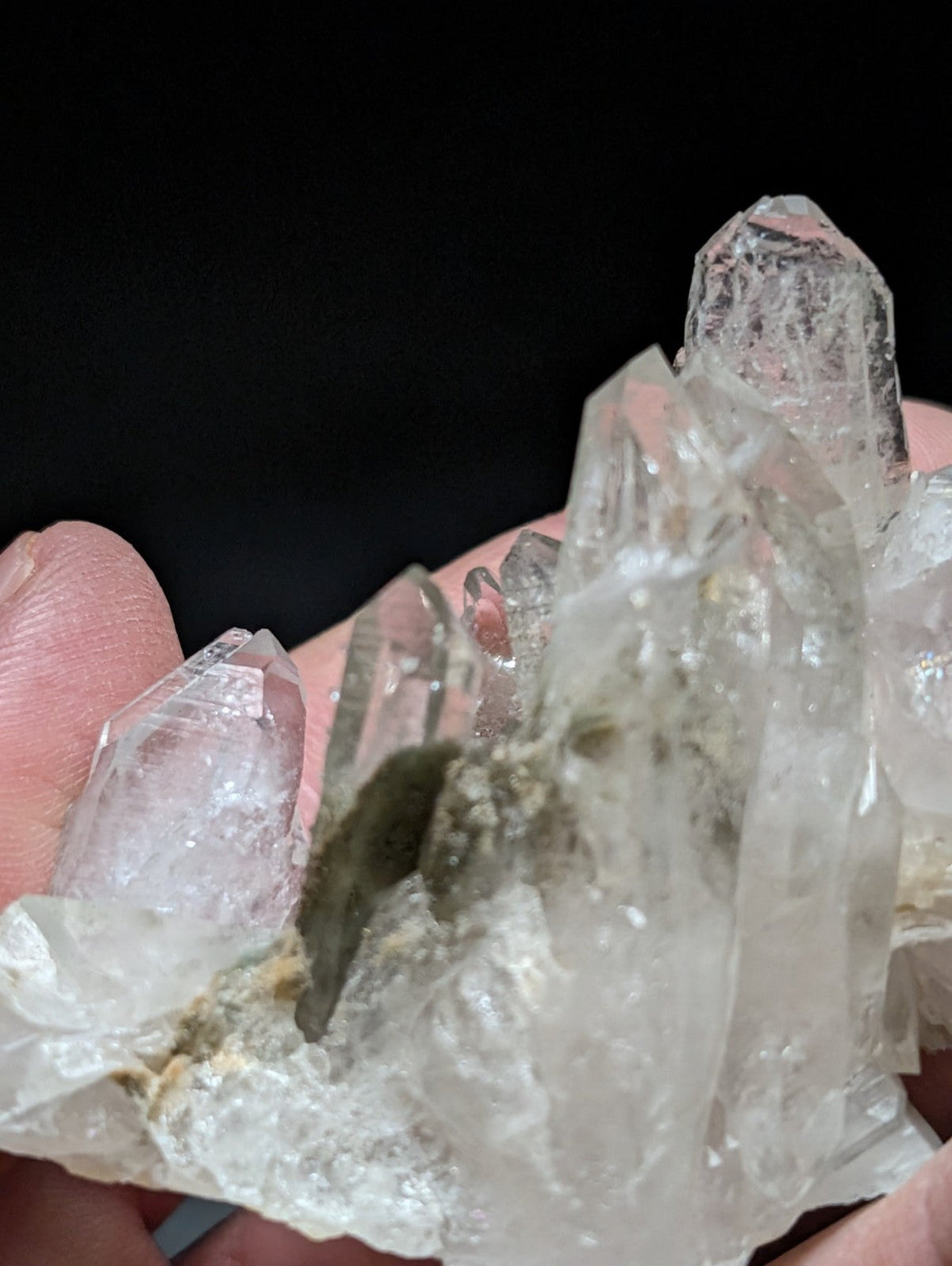 A translucent, clear quartz crystal cluster with sharp facets and a natural base matrix.