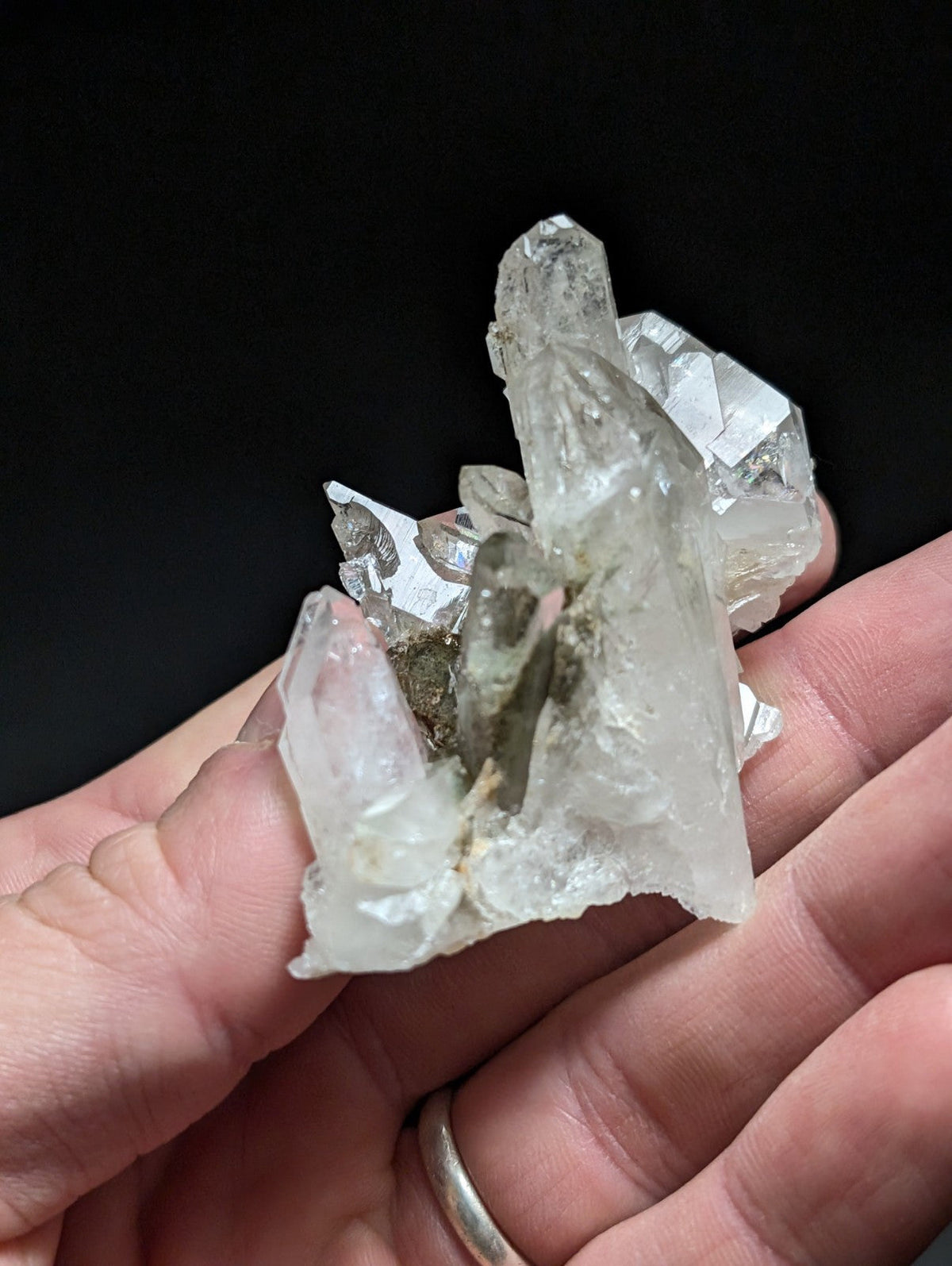 A translucent, clear quartz crystal cluster with sharp facets and a central darker inclusion.
