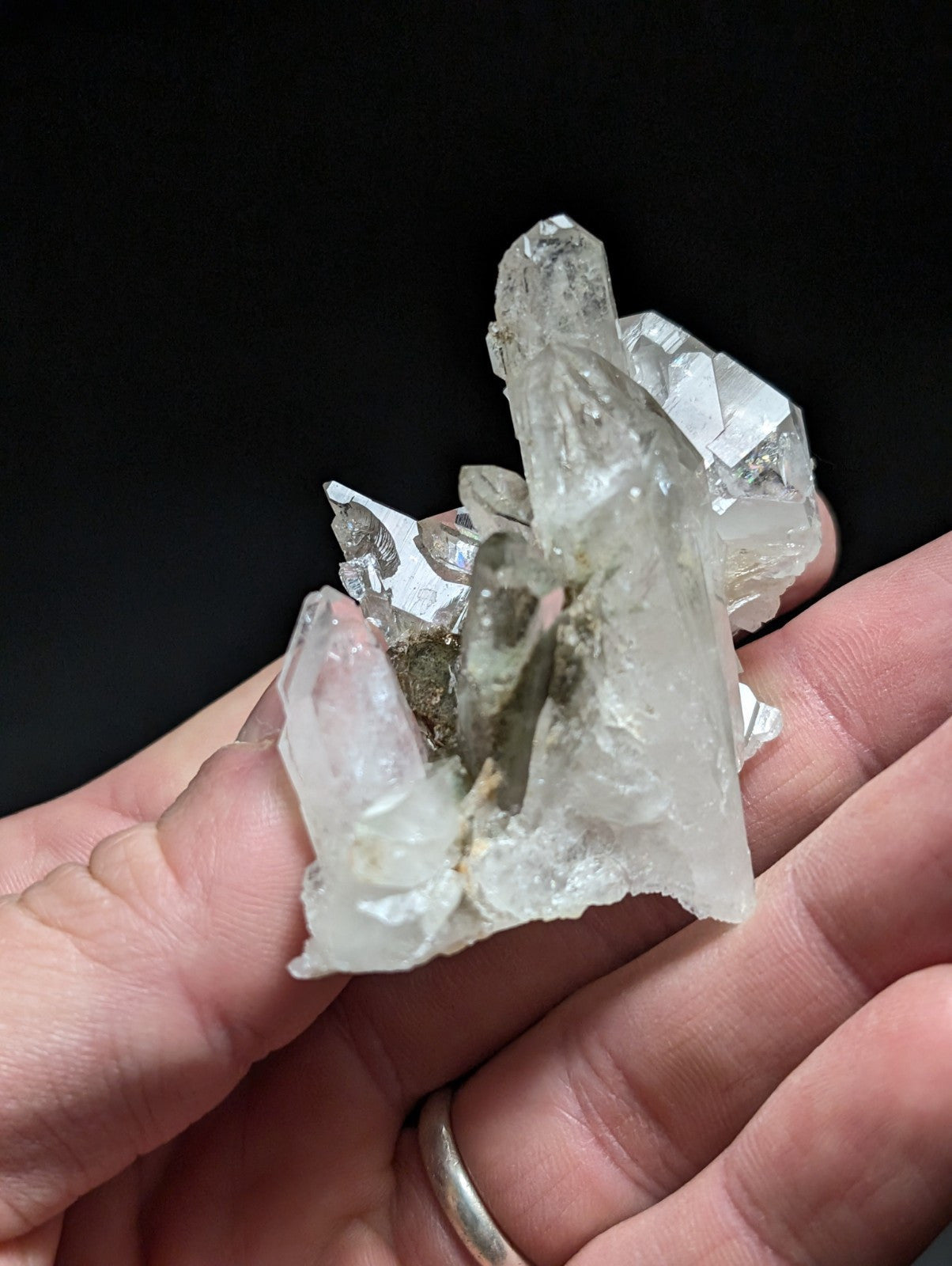 A translucent, clear quartz crystal cluster with sharp facets and a central darker inclusion.