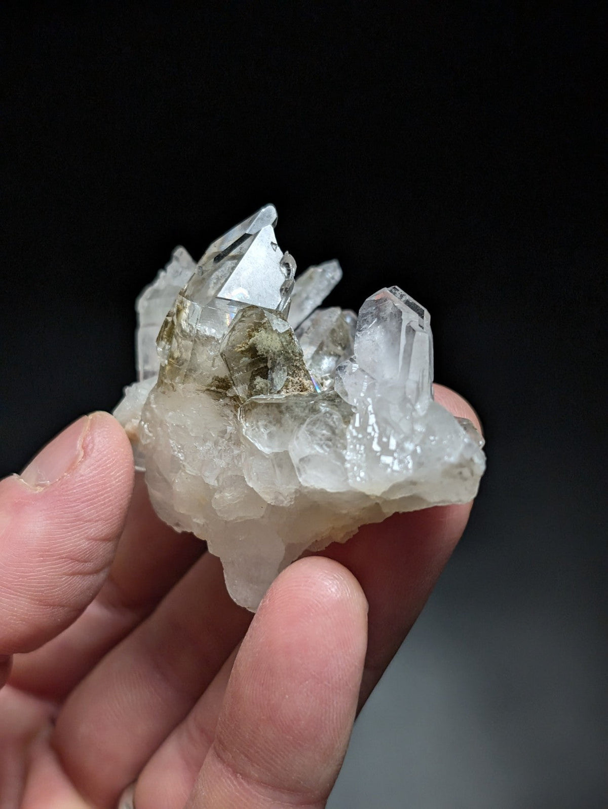 A translucent quartz crystal cluster with clear, faceted points and subtle greenish inclusions.