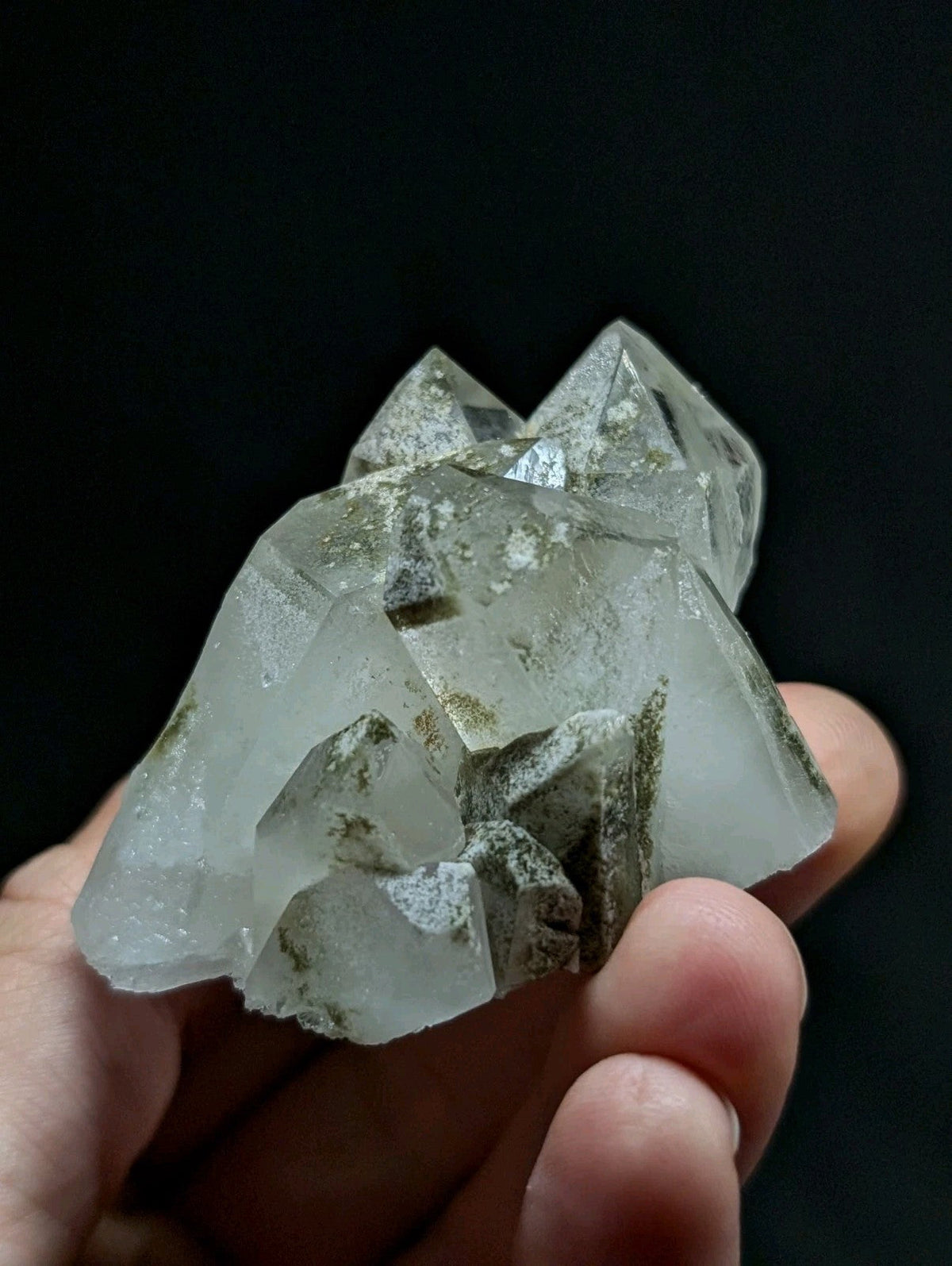 A translucent quartz crystal cluster with pointed, faceted formations and subtle greenish inclusions.