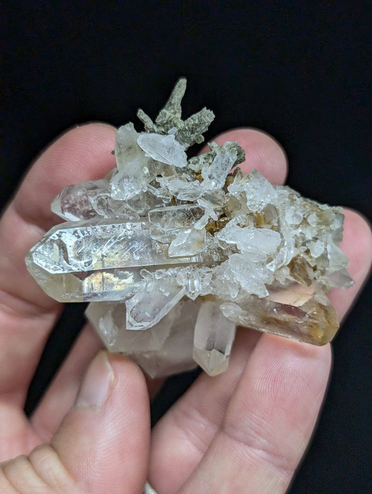 A translucent quartz crystal cluster with clear, pointed prisms and a mix of white and pale yellow hues.
