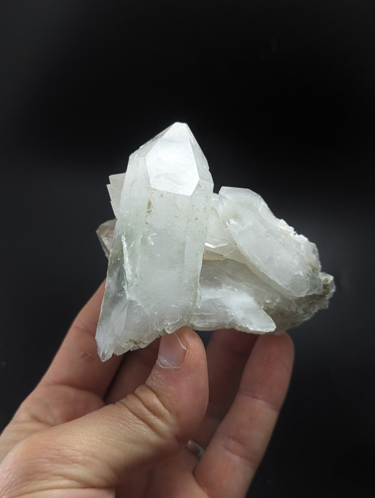 A translucent white quartz crystal cluster with sharp, faceted points and a rougher base.