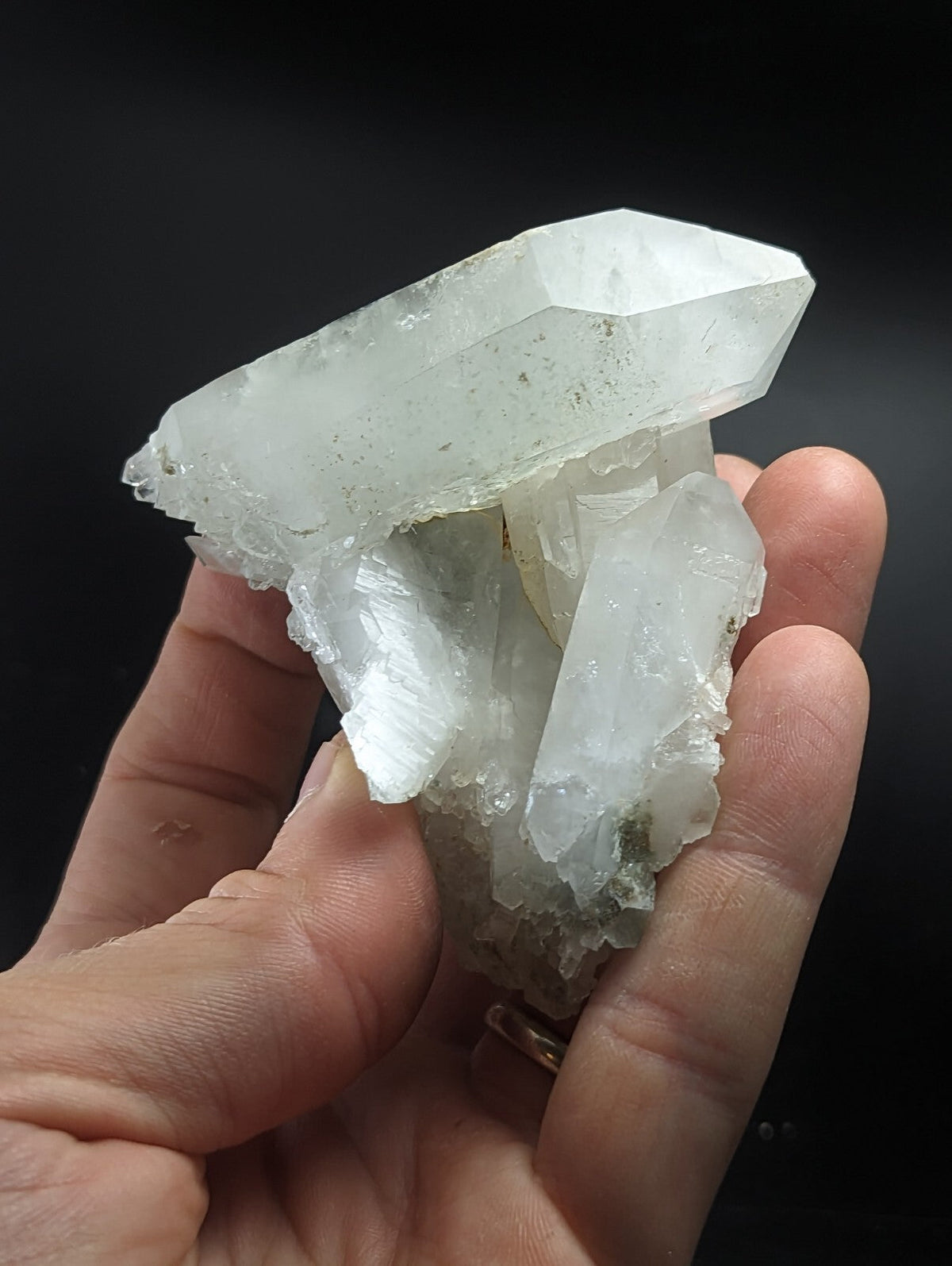 A translucent white quartz crystal cluster with sharp, faceted points and a rough, natural base.