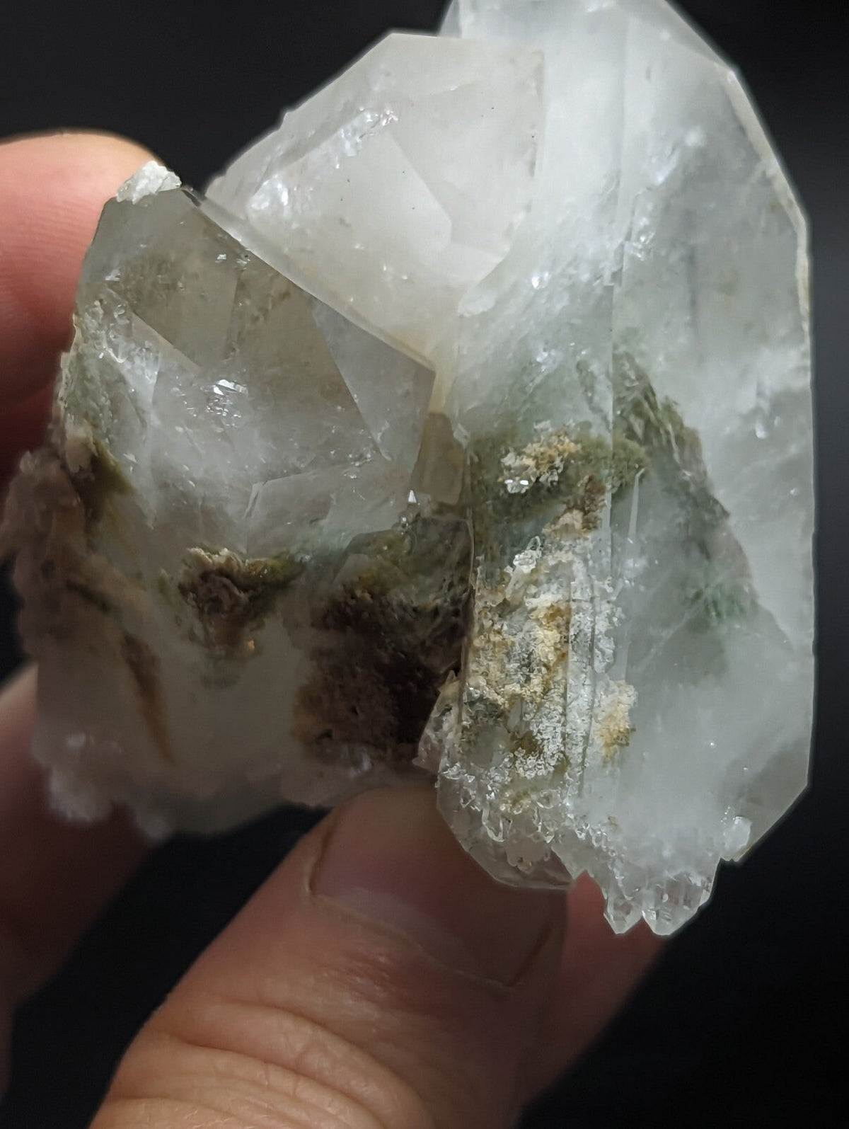 A translucent white quartz crystal cluster with greenish mineral inclusions.
