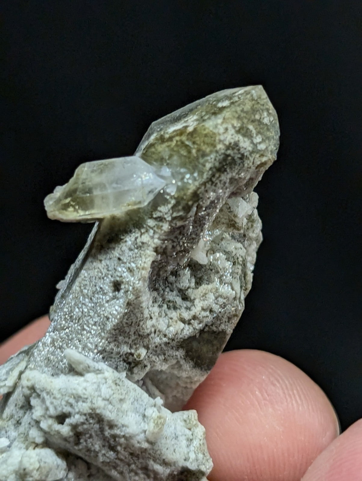 A translucent green crystal cluster with a rough, textured matrix base.