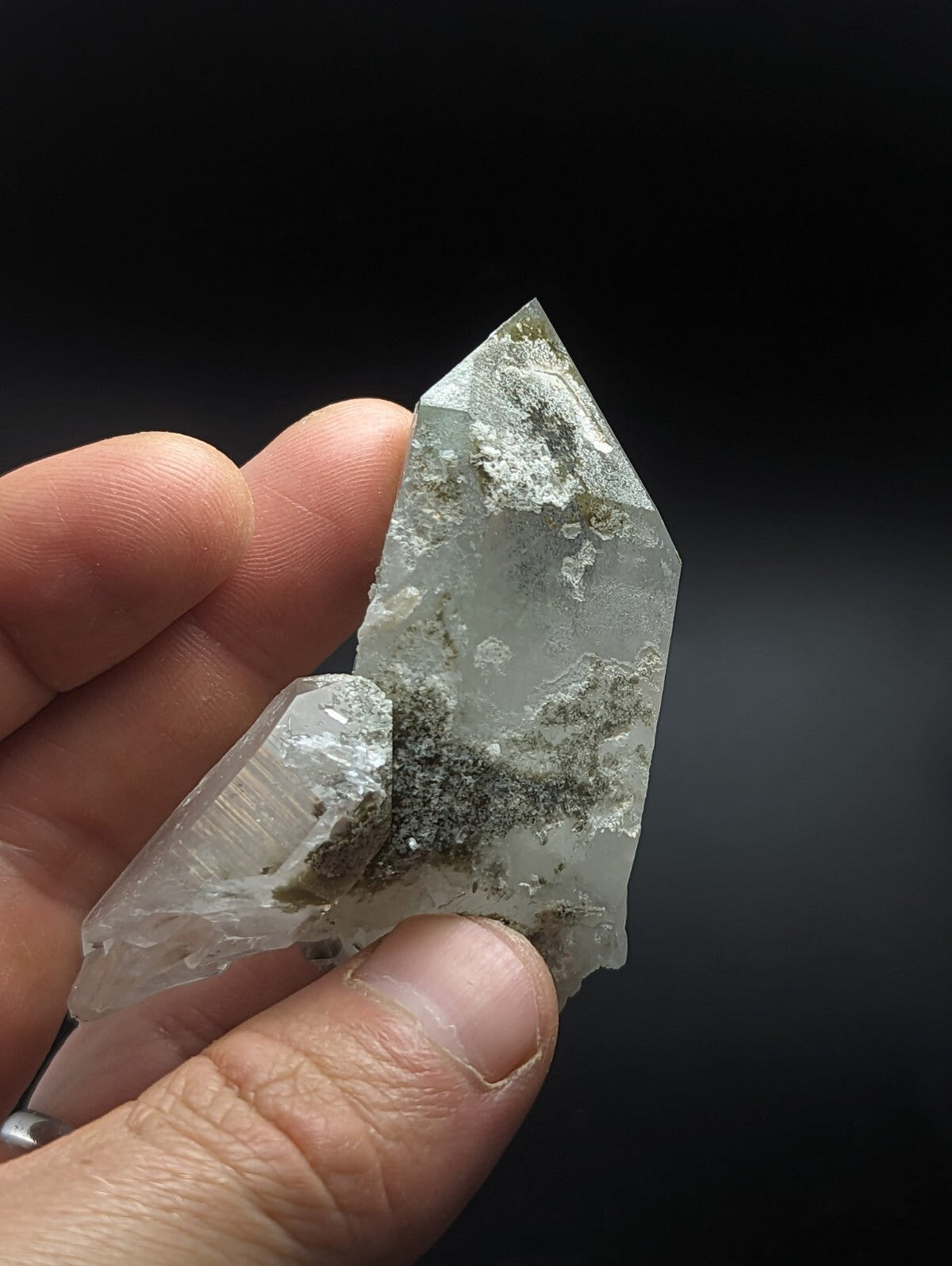 A translucent, pale green quartz crystal with a pointed tip and visible internal inclusions.