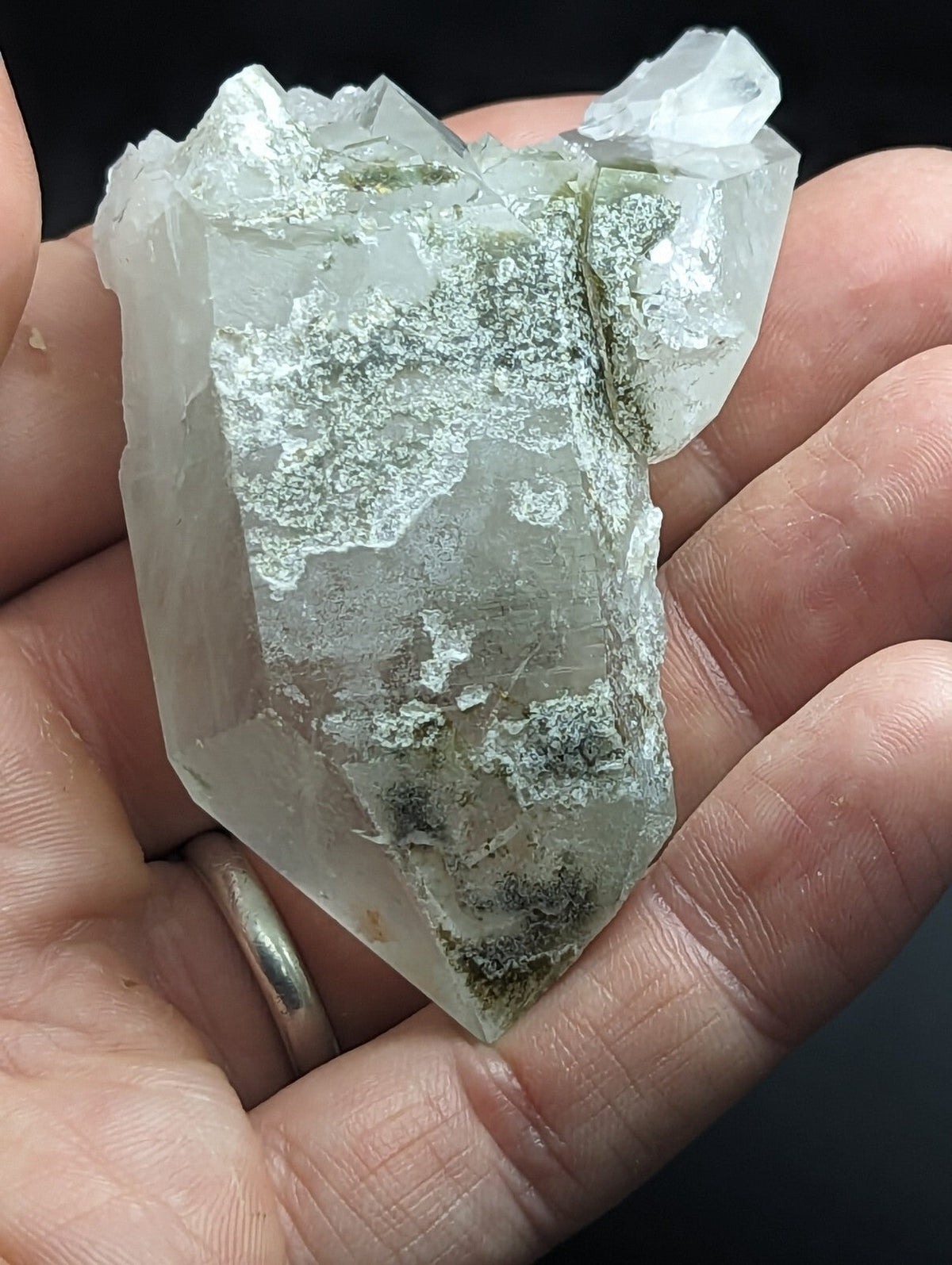 A translucent, pale green quartz crystal with a rough, jagged surface and visible internal veining.