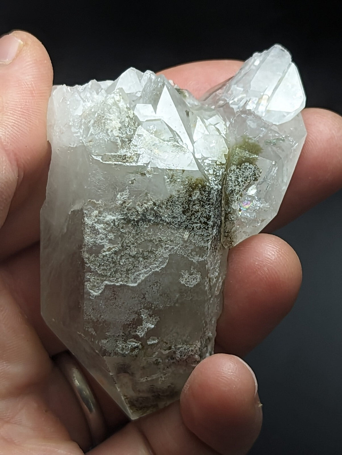 A translucent, clear quartz crystal cluster with a rough, jagged surface and subtle greenish mineral inclusions.