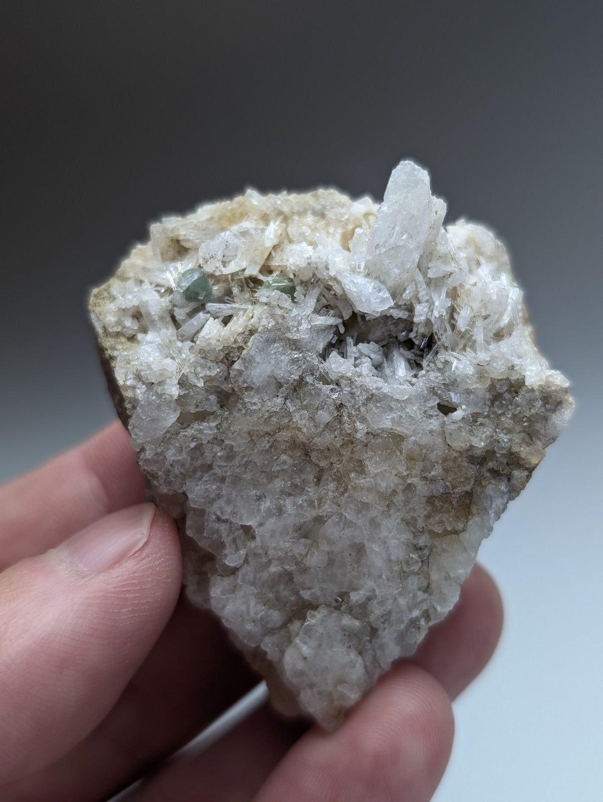 A translucent green cookeite crystalline mineral on rough solution quartz matrix from saline county arkansas rare uv reactive
