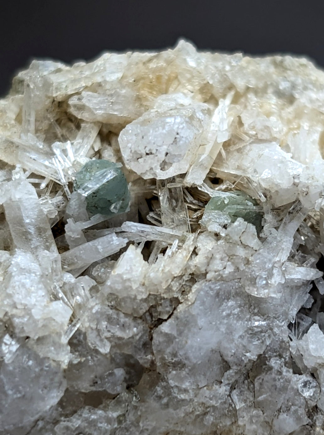 A cluster of translucent white quartz crystals with rare green cookeite gemstones from saline county arkansas, uv reactive