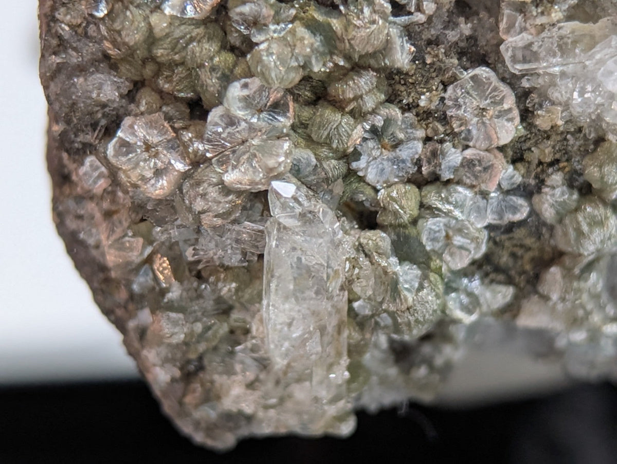 A cluster of translucent, clear quartz crystals with some exhibiting a subtle greenish tint and others displaying faint pink hues.